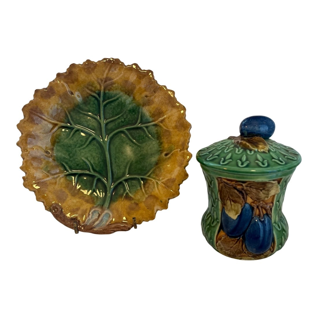 1930s Majolica Lidded Jam Pot Along With Majolica Leaf Form Plate: Lidded plum decorated majolica jam or marmalade jar along, with a , made in Czechoslovakia , majolica leaf form plate. Plate most probably British. Dimensions below are for the jam jar. Plate holder