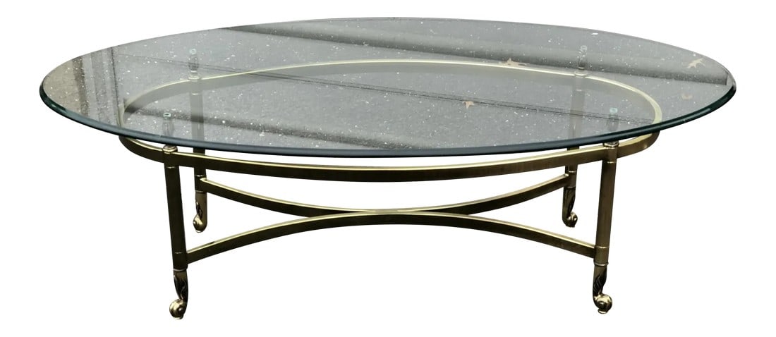 1960s Vintage Art Deco Style Brass Oval Coffee Table: Vintage Oval glass and brass cocktail table with diamond form stretcher, surmounted with a bull-nosed edge glass top and resting on curved feet. Glass in excellent condition, heavy and thick. A