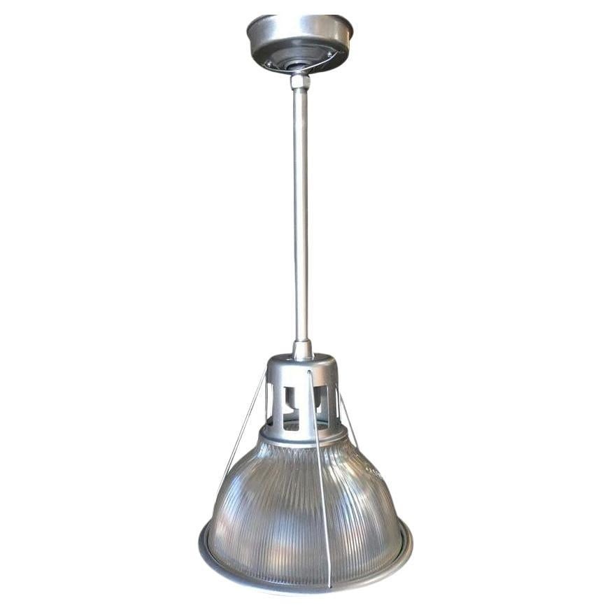 Silver Colored Industrial Ribbed Pendant Lamp by Holophane: Title: Silver Colored Industrial Ribbed Pendant Lamp by Holophane Description: Circa 1938 very heavy made, industrial, ribbed glass Holophane Pendant lamp refinished in a bright chrome-like finish.