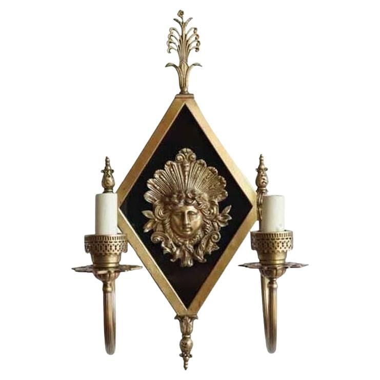 Edwardian era Neoclassical Bronze Greek Face 2-Arm Sconce, 2 Available: Title: Edwardian era Neoclassical Bronze Greek Face 2-Arm Sconce, 2 Available Description: Early 20th century Neoclassical Bronze 2-Arm Sconces with a center Greek face and black enamel accent color. 