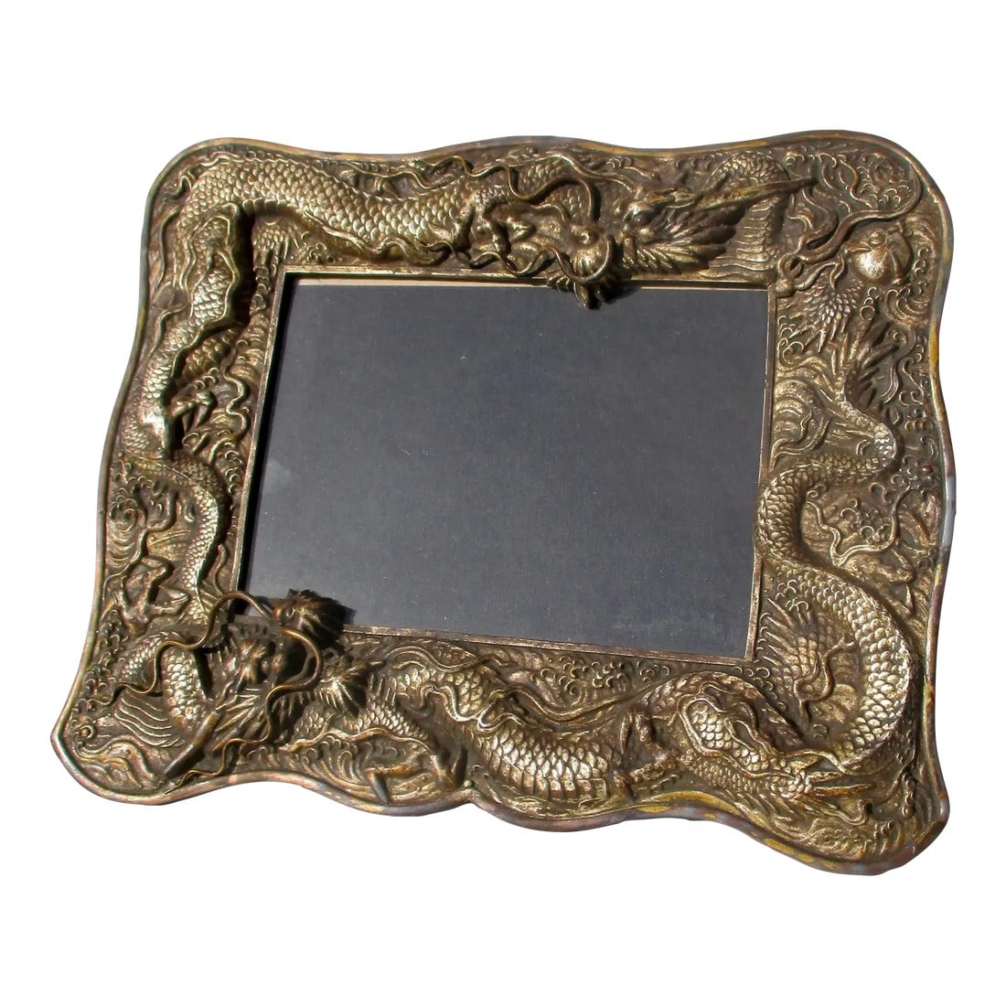 Antique Dragon Photo Frame Circa 1920s: Early 20th-century photo frame. Surrounded by two dragons chasing the flaming jewel. A horizontal format with a back stand and brass eyelets for a silk rope hanger. Gilt and silver wash over a metal