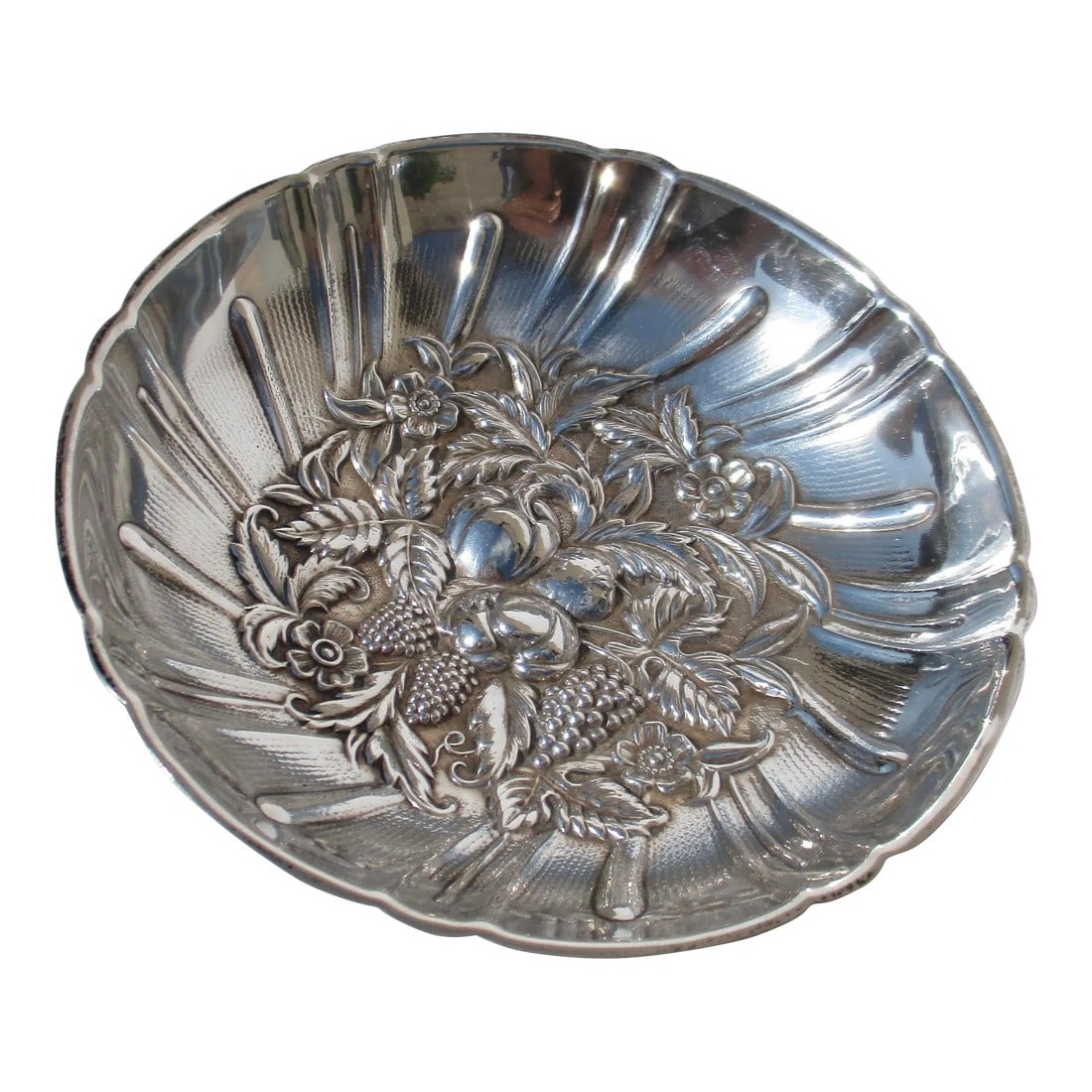Sterling Silver Cabdy Dish by Kirk & Son Circa 1940s: Kirk & Son Sterling 431 , Shallow side dish with relief design of fruits, flowers, and berries and a sectional design with spinning rays from the center design. A scalloped rim and three ball feet.