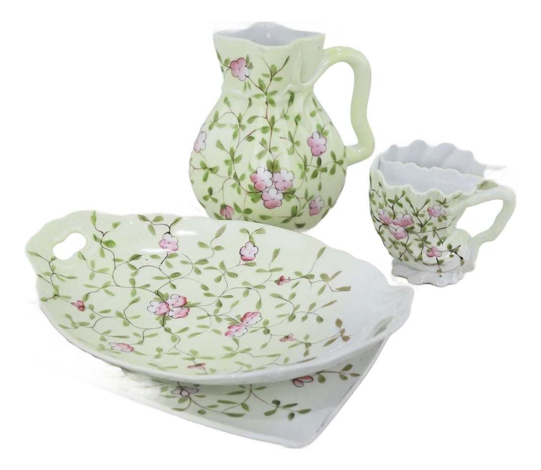 Vintage Hand-Painted Porcelain Pitcher & Plates Set With Floral Design: This elegant porcelain set features a soft green background adorned with delicate hand-painted pink flowers, evoking the charm of vintage European tableware. The gracefully curved pitcher and matching