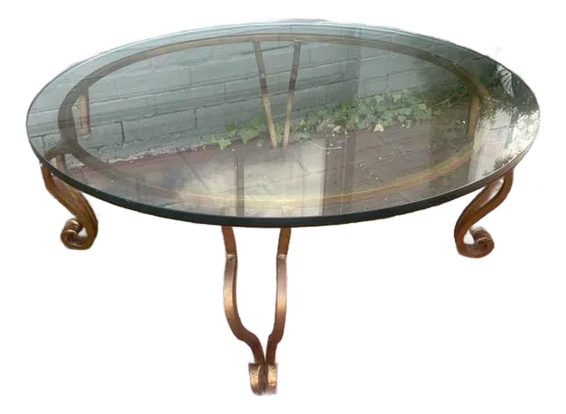 Mid Century Modern Wrought Gilt Iron Coffee Table With Glass Top. Circa 1975.: This mid-century modern gilt wrought gilt iron coffee table with glass top in the manner of Ramsey, circa 1975. Height: 16.25 in (41.28 cm) Diameter: 42 in (106.68 cm) Condition: Alterations: