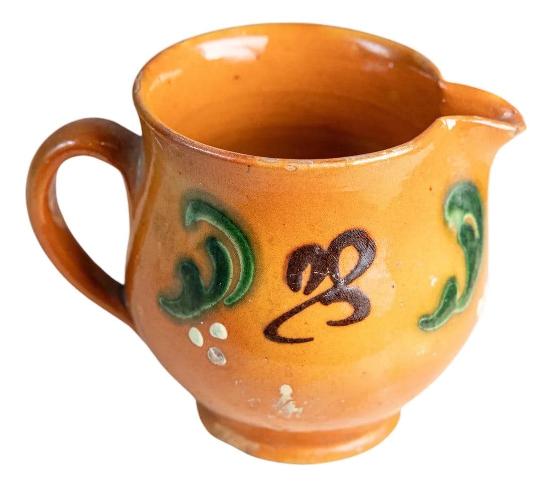 Early 20th Century French Glazed Terracotta Miniature Pitcher: A petite and charming French terracotta pitcher dating to the early 20th century, featuring a warm amber glaze and hand-applied slip decoration in green, white, and deep brown. Measuring just 4.5