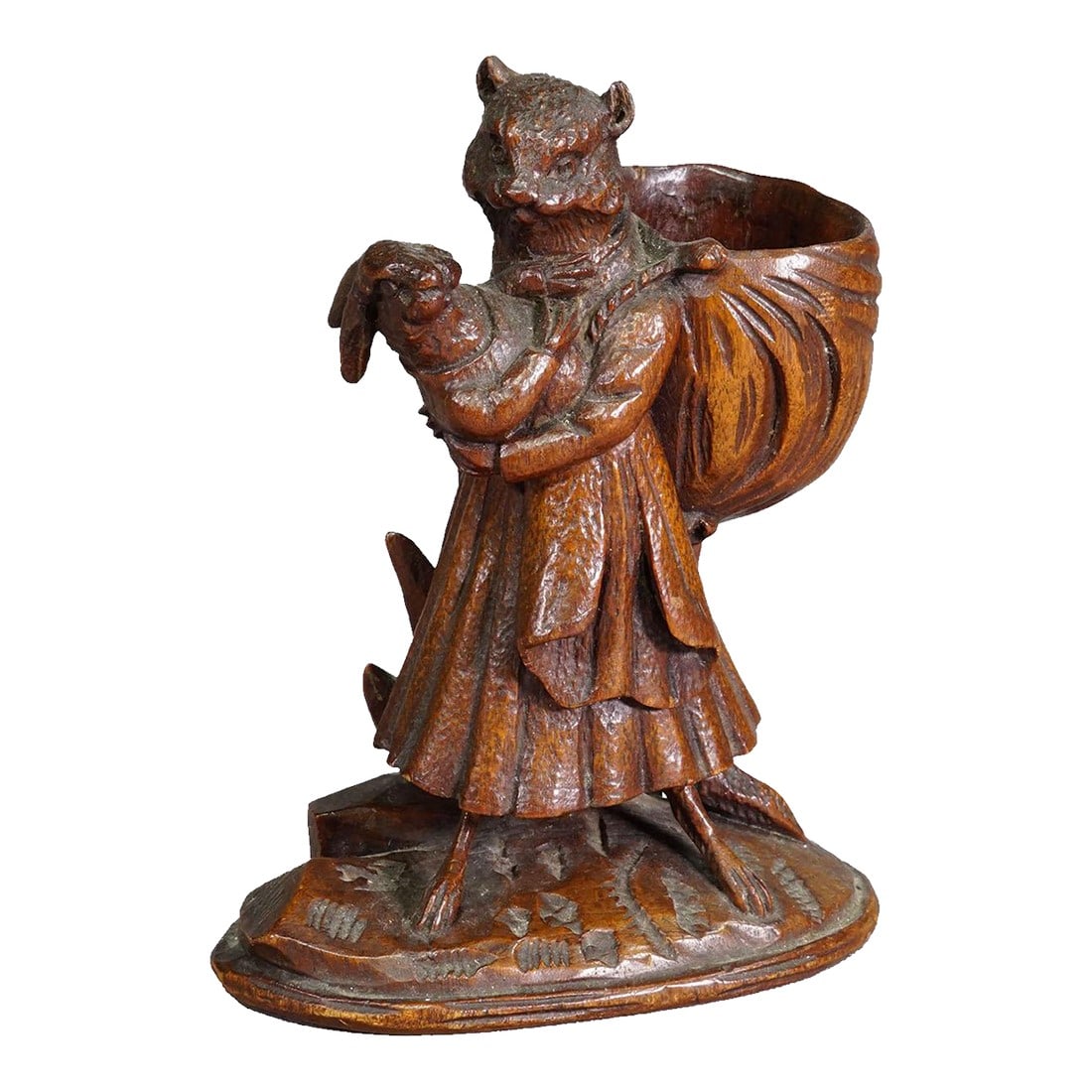 Wooden Sculpture Cat With Rabbit Handcarved Ca. 1900s: Wooden Sculpture Cat with Rabbit Handcarved ca. 1900s A hand-carved wooden sculpture depicting a cat in a flowing robe gently holding a rabbit in her arms. She carries a large, draped sack on her