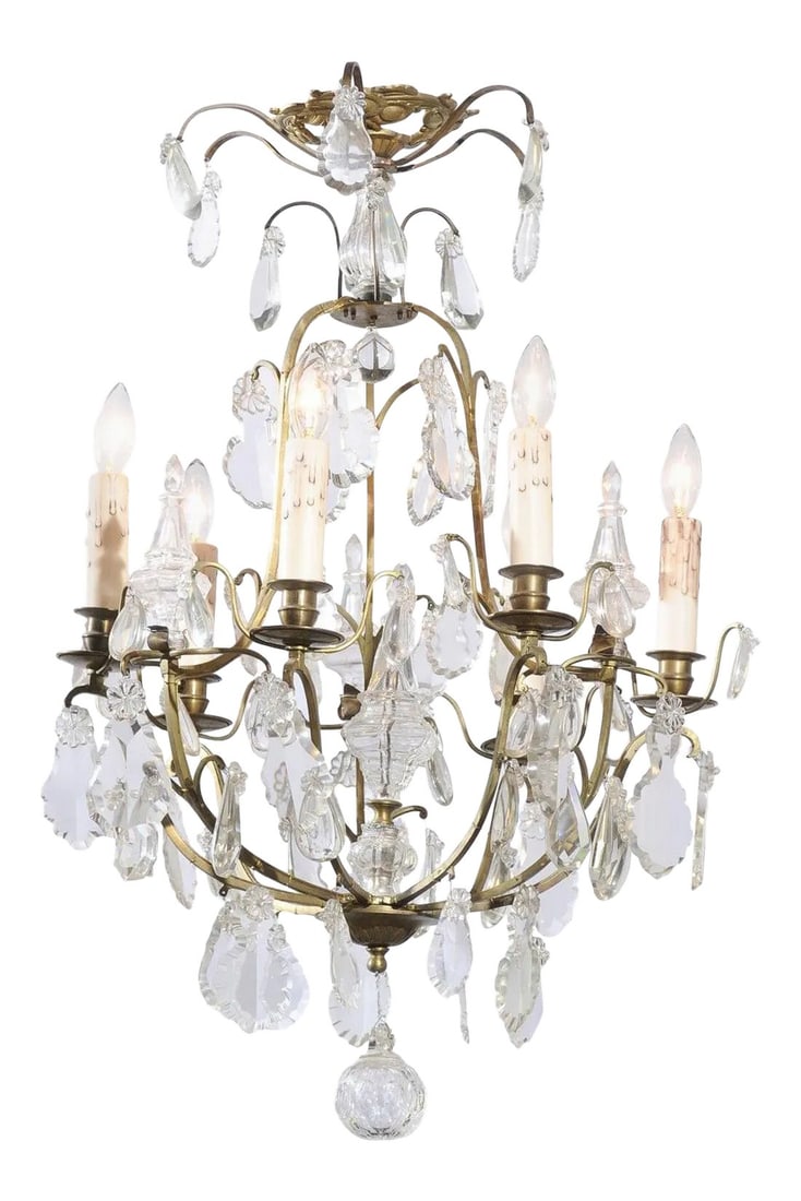 French 19th Century Six-Light Crystal Chandelier with Scrolled Brass Armature: A French six-light crystal chandelier from the 19th century, with brass armature, pendeloques and round finial. Born in France during the politically dynamic 19th century, this lovely six-light