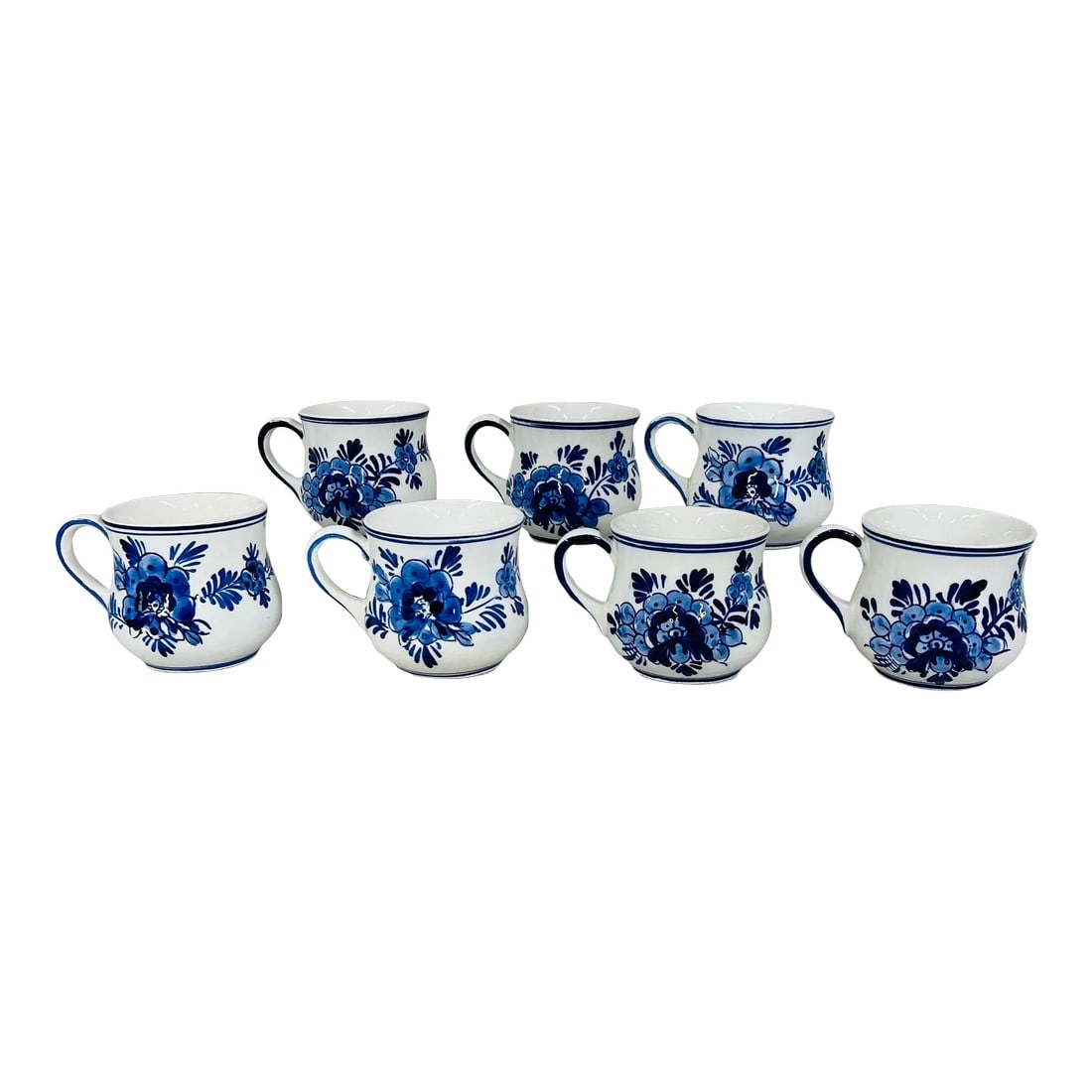 Mid 20th Century Blue Delft Mugs - Set of 7: Set of seven Delft blue mugs featuring windmills on one side snd floral design on the other. Measure 4.5" wide with handle, 3.25" without handle x 3" high. 2 have some staining in inside from use.
