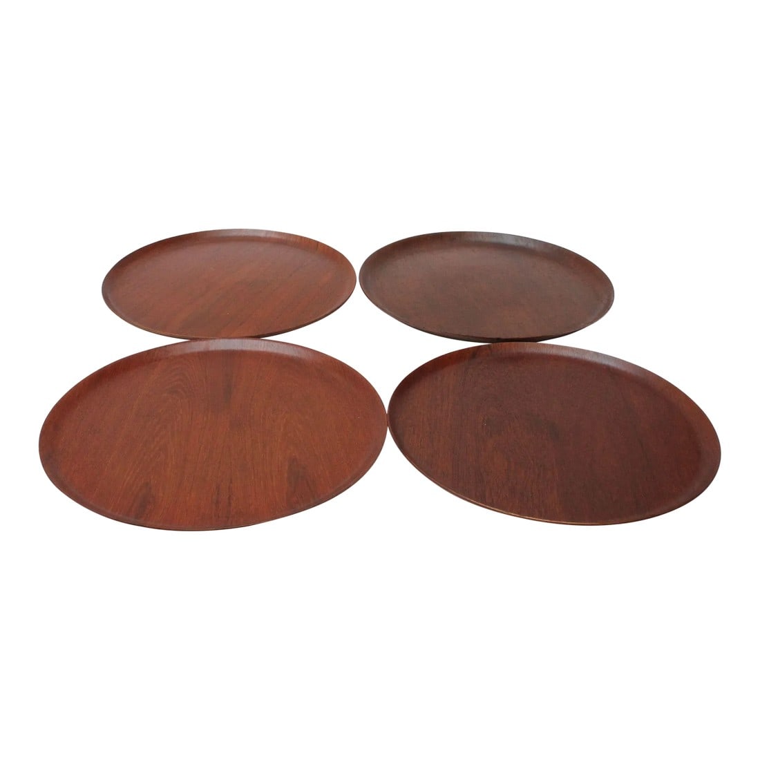 Collection of Four Large Swedish Modern Round Teak Trays: Set of four similar Swedish teak trays with curved edges, ca. 1960s. Slight variations in grain, color, and size (diameters range from 17.25" to 17.63" and heights from .75" to .88" -- only marginal