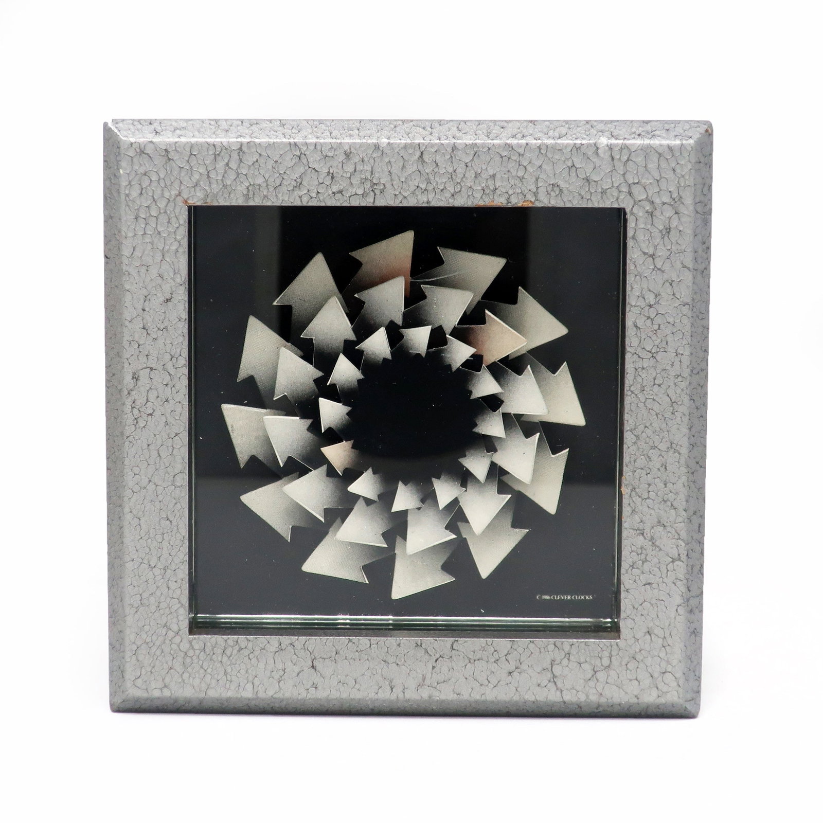 1986 Postmodern Desk Clock by Douglas Chalk for Clever Clocks: A rare 1986 desk clock designed by Douglas Chalk for Clever Clock. A silver/gray square wood case, a series of arrows making pinwheels for the hands (one arrow in each is colored so the viewer can