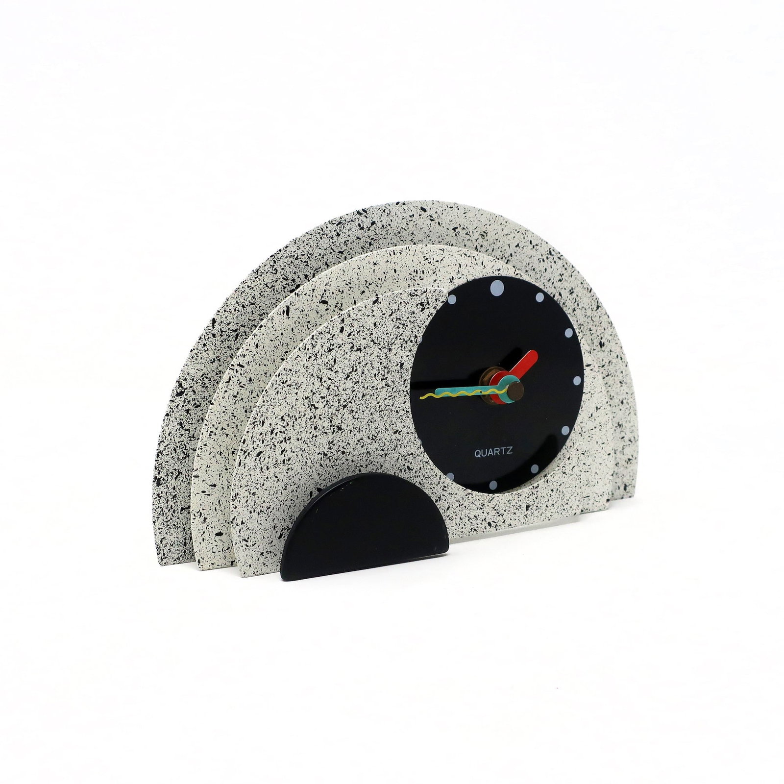 1980s Gray & Black Stacked Desk or Mantel Clock: With a stunning combination of spotted gray and black enameled metal, black lucite accents, and primary colored hands, this postmodern clock is designed with a stacked semi-circle design that gives it