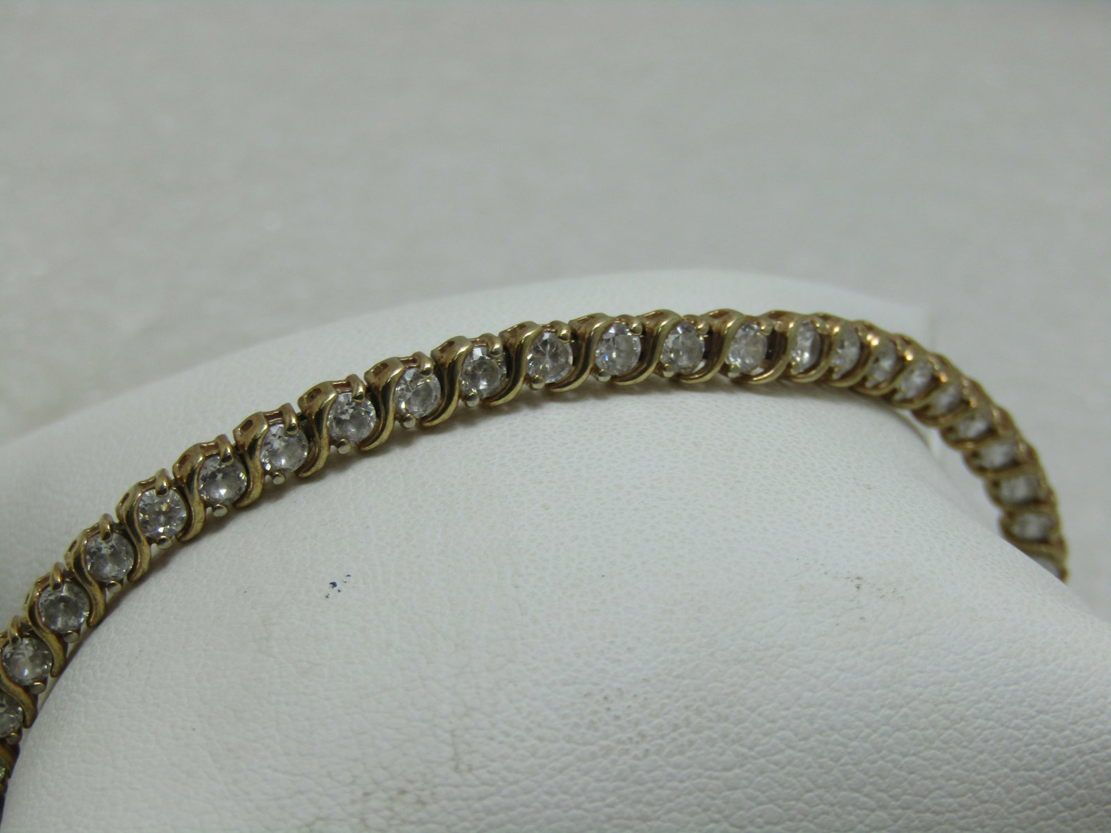 Sterling Gold Vermeil CZ Tennis Bracelet, 7.5", 8+ TCW: Sterling Gold Vermeil CZ Tennis Bracelet, 7.5", 8+ TCW, 11.40 grams, and appx. 4.5mm wide. This has 45 clear CZs that are each appx. 3mm to 3.3mm. There s a curved subtle X shape dividing each stone