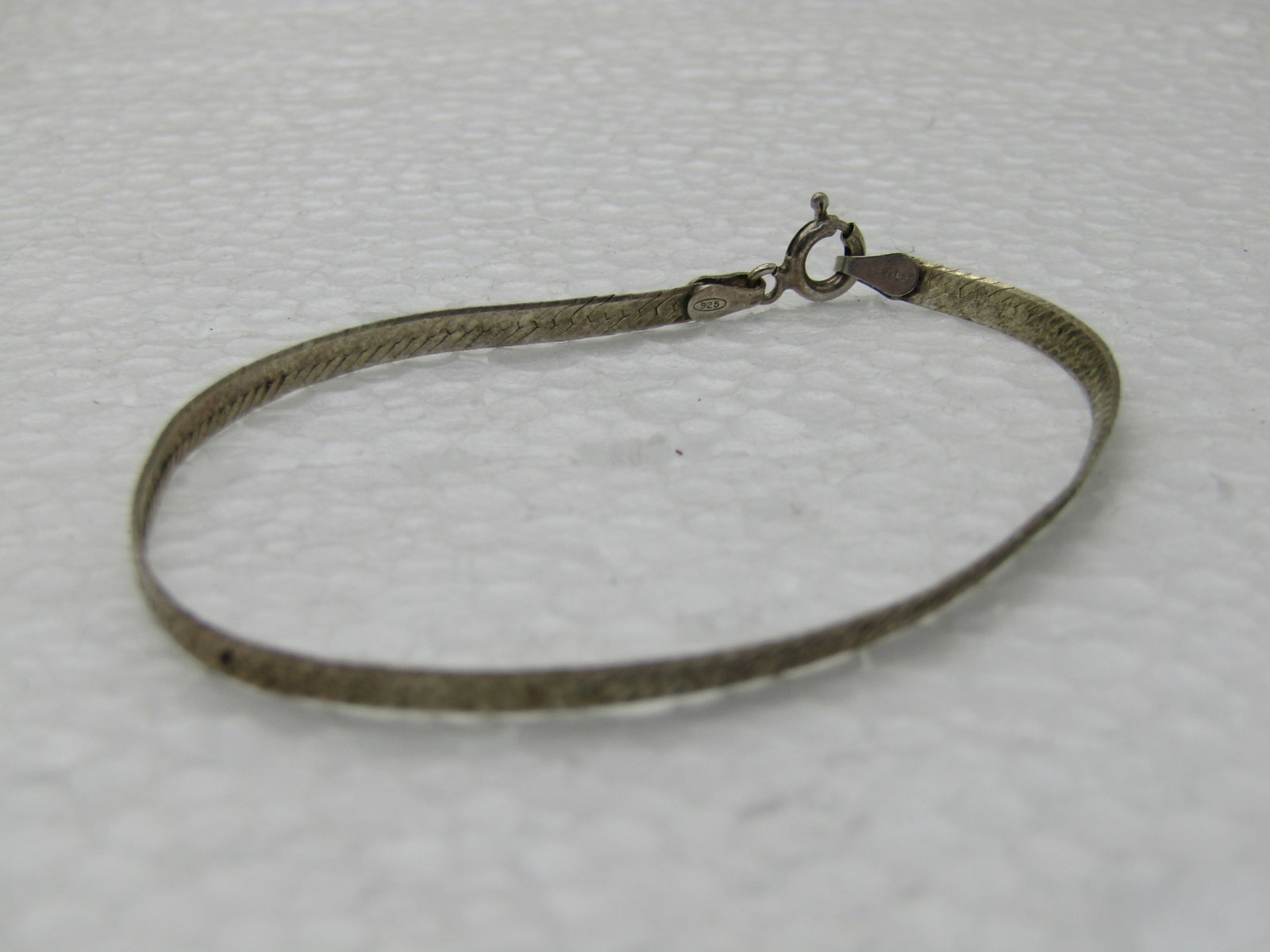 Vintage Sterling Silver 3mm Herringbone Bracelet, 7": Vintage Sterling Silver 3mm Herringbone Bracelet, 7", Italy. Weight is papx. 2.13 grams. Marked ,925 and tested, spring clasp. Some light wear with oxidation that can be polished. Good condition. (INV
