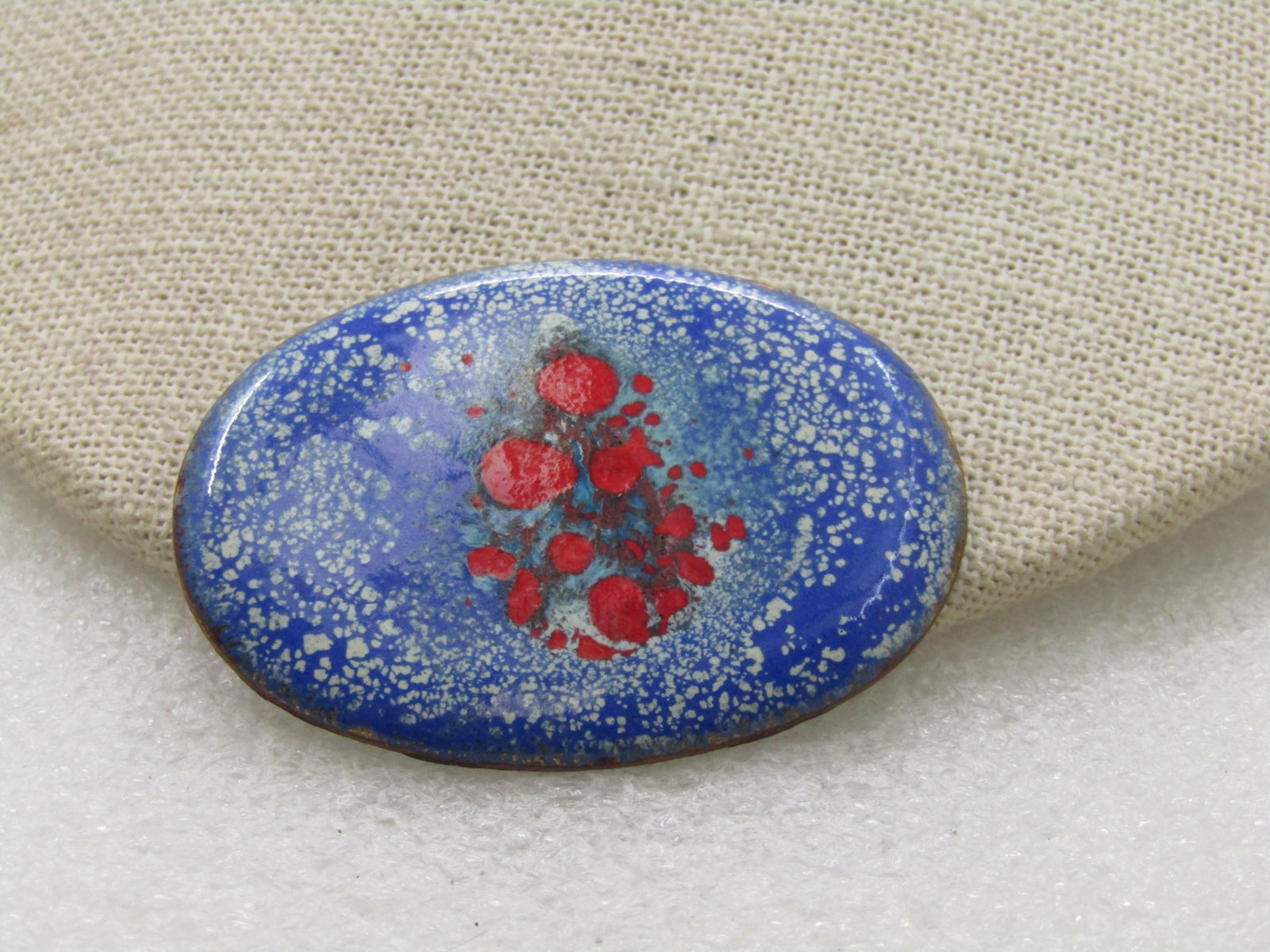 Vintage Enameled Over Copper Brooch, Red, White, Blue, 2": Vintage Enameled Over Copper Brooch, Red, White, Blue, 2" by 1.5". Likely hand made. Blue background with speckled white accents and red splotches in the center. Age is appx. 1960's-1970's. Good