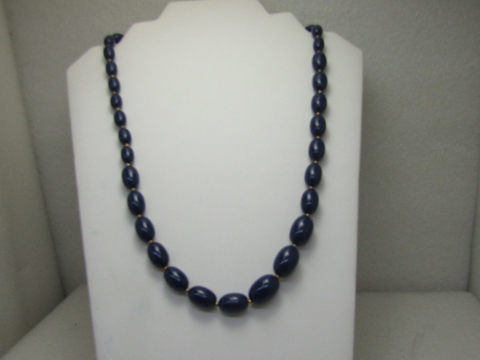 Vintage Graduated Navy Blue Beaded Necklace, 22", 1970's: Vintage Graduated Navy Blue Beaded Necklace, 22", 1970's, Oblong beads graduated from 11mm wide to 17.5mm wide with gold tone spacer beds. Spring clasp, similar to Monet at that time. (INV. W.22020.7 