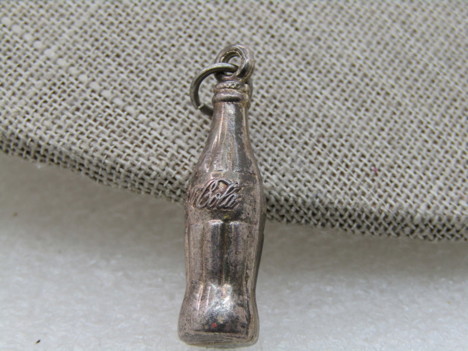 Vintage Silver Plated Coke Bottle Pendant/Charm, 1.25": Vintage Silver Plated Coke Bottle Pendant/Charm, 1.25" tall and appx. 3/8" wide. It is nor marked or signed, light wear. Tests lightly as silver but believe it is plated. It is not sterling. Good to v