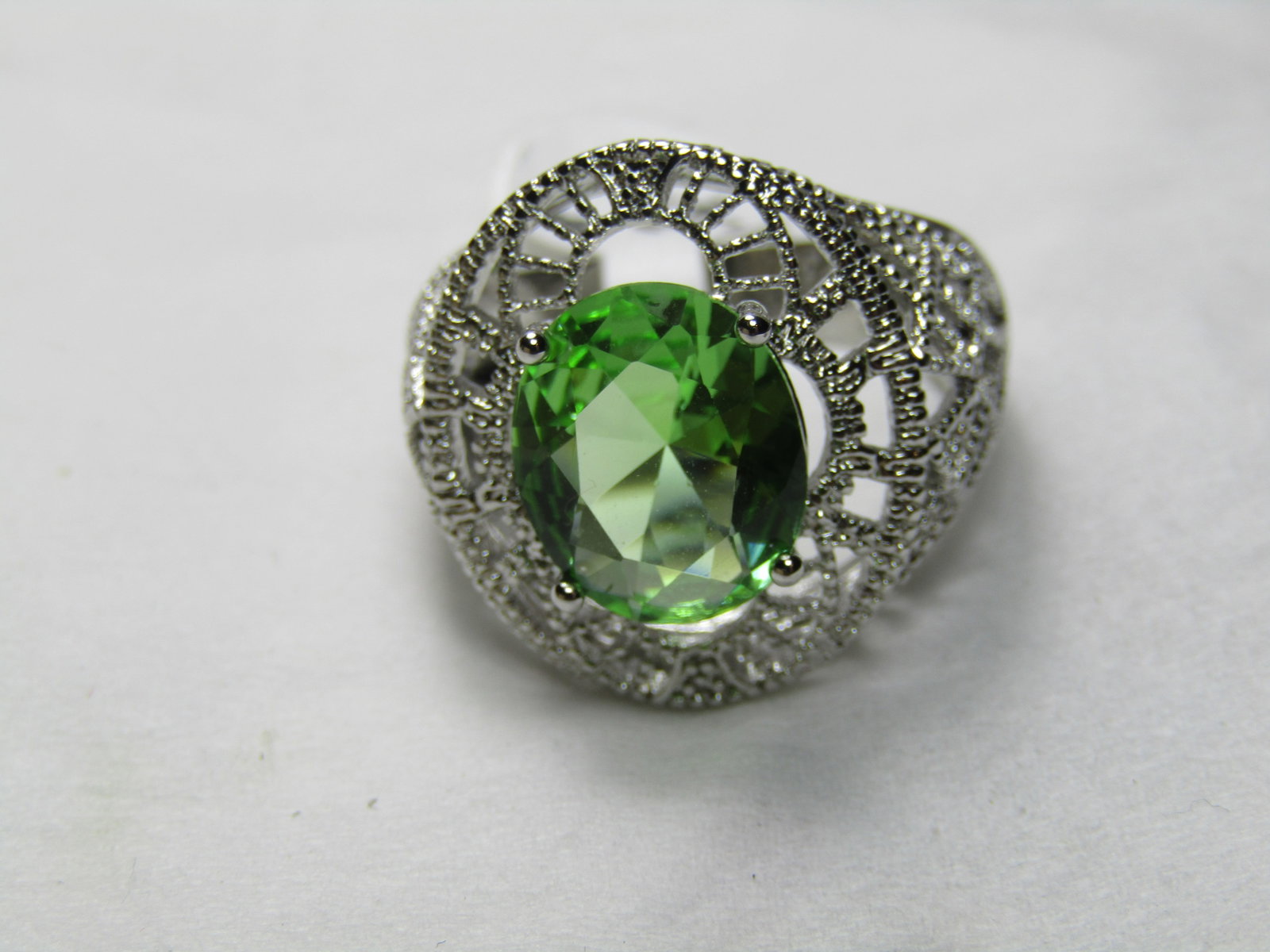 Silver Filigree Green Crystal Ring, Sz. 8.5, Statement Ring: Silver Filigree Green Crystal Ring, Sz. 8.5, Statement Ring. It has a peridot green colored crystal stone that is a faceted oval that is appx. 11.5mm by 9.5mm . The ring has a filigree design everywhe