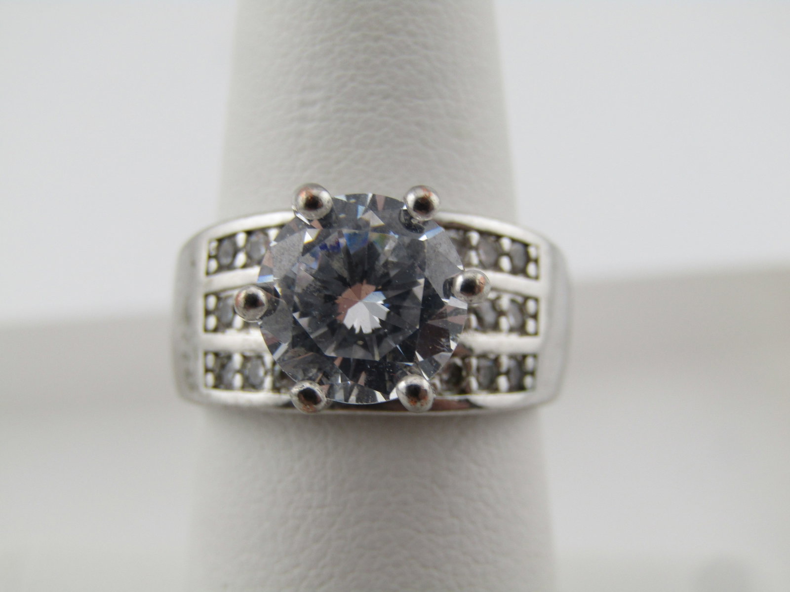 Silver Large Clear Stone Wide Engagement/Cocktail Ring, Sz. 7, 1980's-1990's: Silver Large Clear Stone Wide Engagement/Cocktail Ring, Sz. 7. 1980's-1990's. This is silver plated and not .925 as it is marked. It has an appx. 8.5mm clear stone set with six prongs over a 9.5m wide