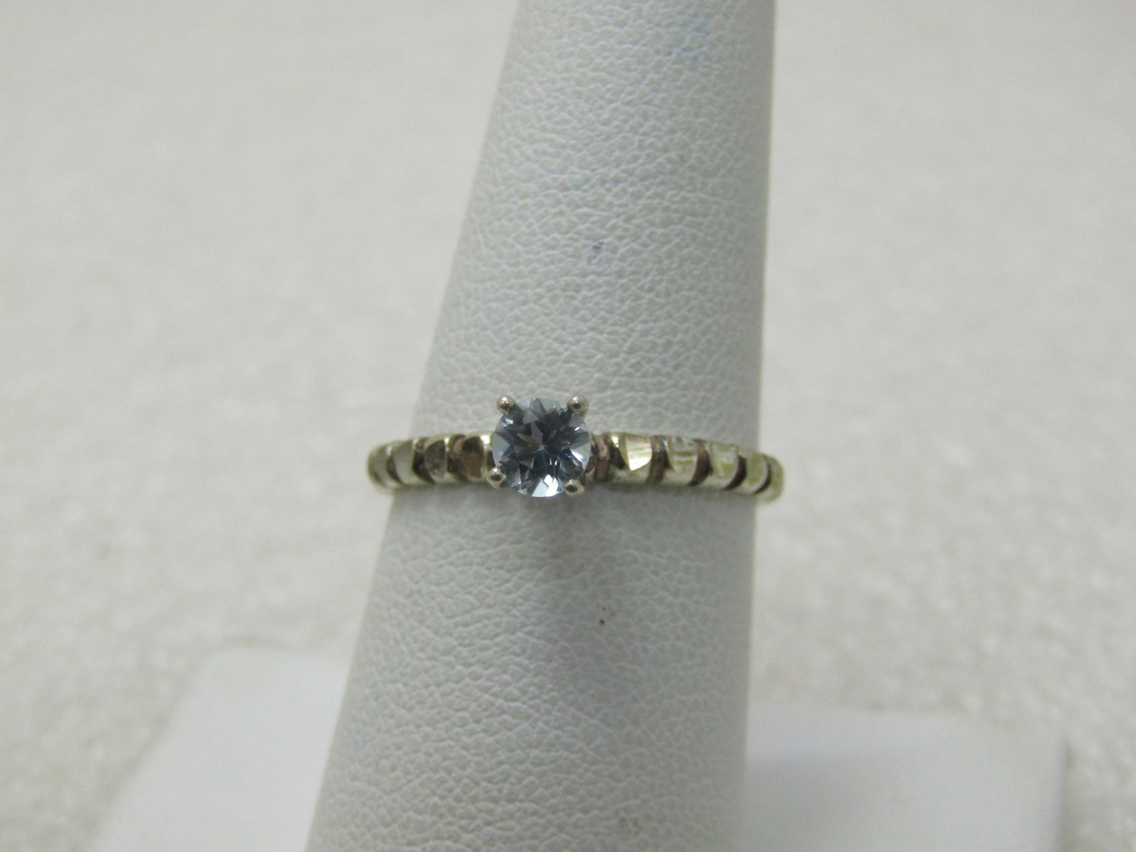 Vintage Blue Topaz Solitaire Ring, Sz. 8, Notched Band: Vintage Blue Topaz Solitaire Ring, Sz. 8, Notched Band, .25 CT blue topaz round cut stone. Sits high on the finger and set with four prongs. The band on either side has diamond cut notches that give t