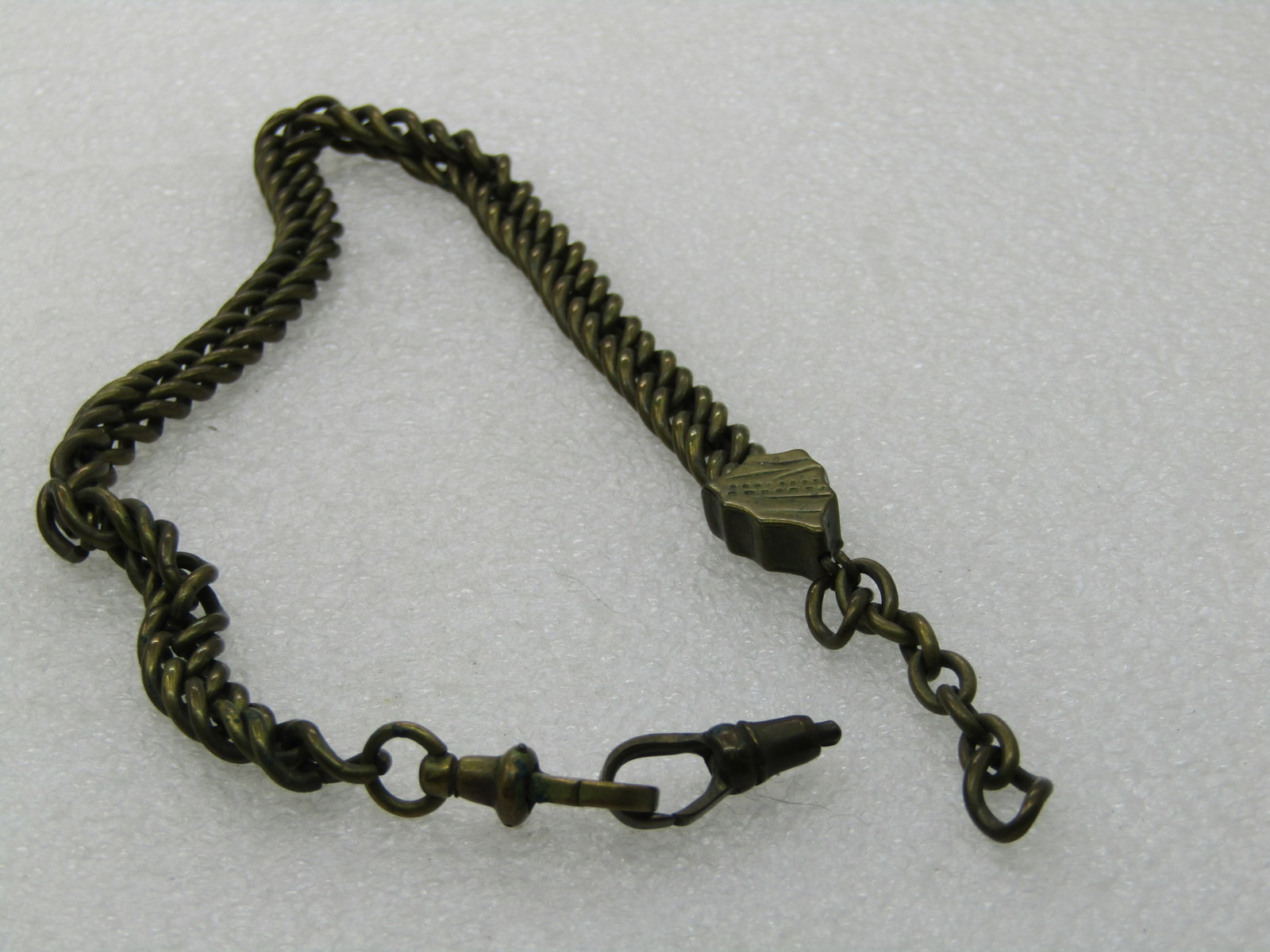 Vintage 7mm Watch Chain, 12", Brass: Vintage 7mm Watch Chain, 12", Brass. This has the clasp on one end but is missing the bar on the other. It has an etched triagular piece on the end where the bar would be. See photos. Age is appx.