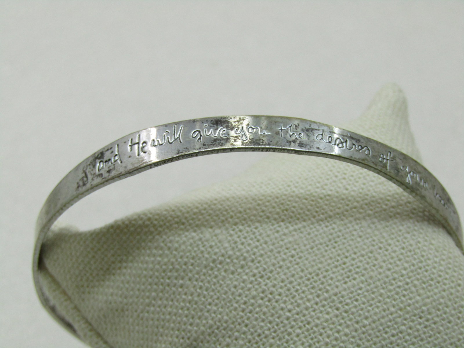 Vintage "And He Will Give You the Desires of Your Heart" Bangle Bracelet, 8.75": Vintage "And He Will Give You the Desires of Your Heart" Bangle Bracelet, 8.75". It has a wavy design that is 7.4mm wide in some spots and 5mm in other spots. The writing is recessed. It has a maker's