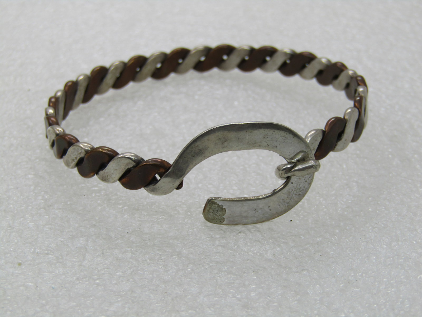Vintage Sterling & Copper Bangle Bracelet, 7.5", Hook buckle clasp.: Vintage Sterling & Copper Bangle Bracelet, 7.5", 19.57 grams and 6.5mm wide. The opening is 2.5". This is an angled alternating braid of sterling and copper. It has a belt-like hook clasp in sterling 