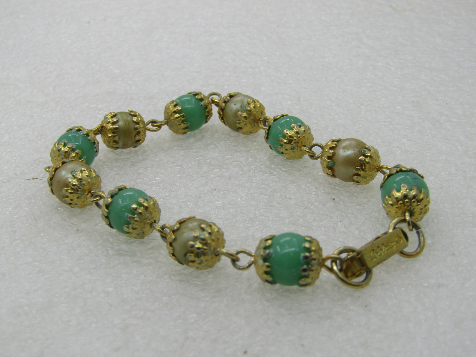 Vintage Celebrith Faux Pearl Green Glass Bracelet, 7.5": Vintage Celebrith Faux Pearl Green Glass Bracelet, 7.5", 8mm wide faux pearl and green glass beaded, gold tone with prong-like end caps and a flip clasp. There is a necklace to this set that I have an
