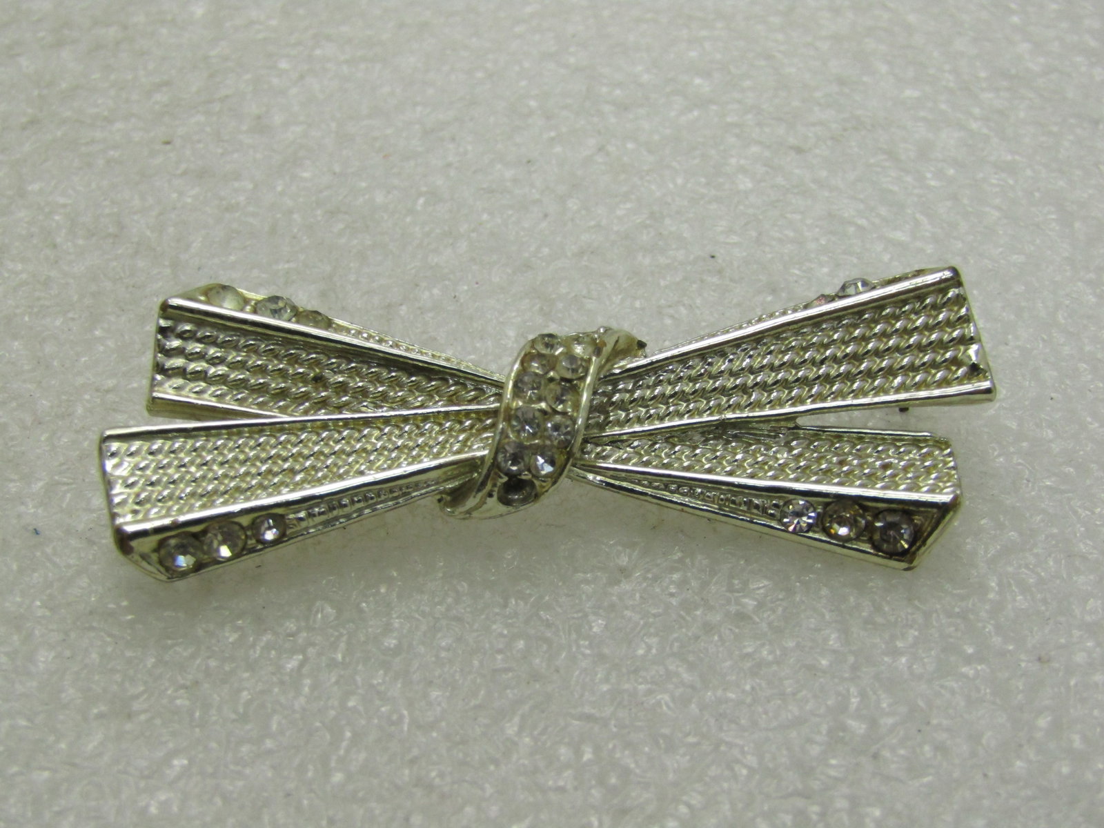 Vintage Gold Tone Art Deco Rhinestone Brooch, Long X Design, 1950's-1960's.: Vintage Gold Tone Art Deco Rhinestone Brooch, Long X Design, 1950's-1960's. Nearly 2.5" wide and 3/4" tall - textured recessed center to the X portion of the brooch with rhinestones accents on top,