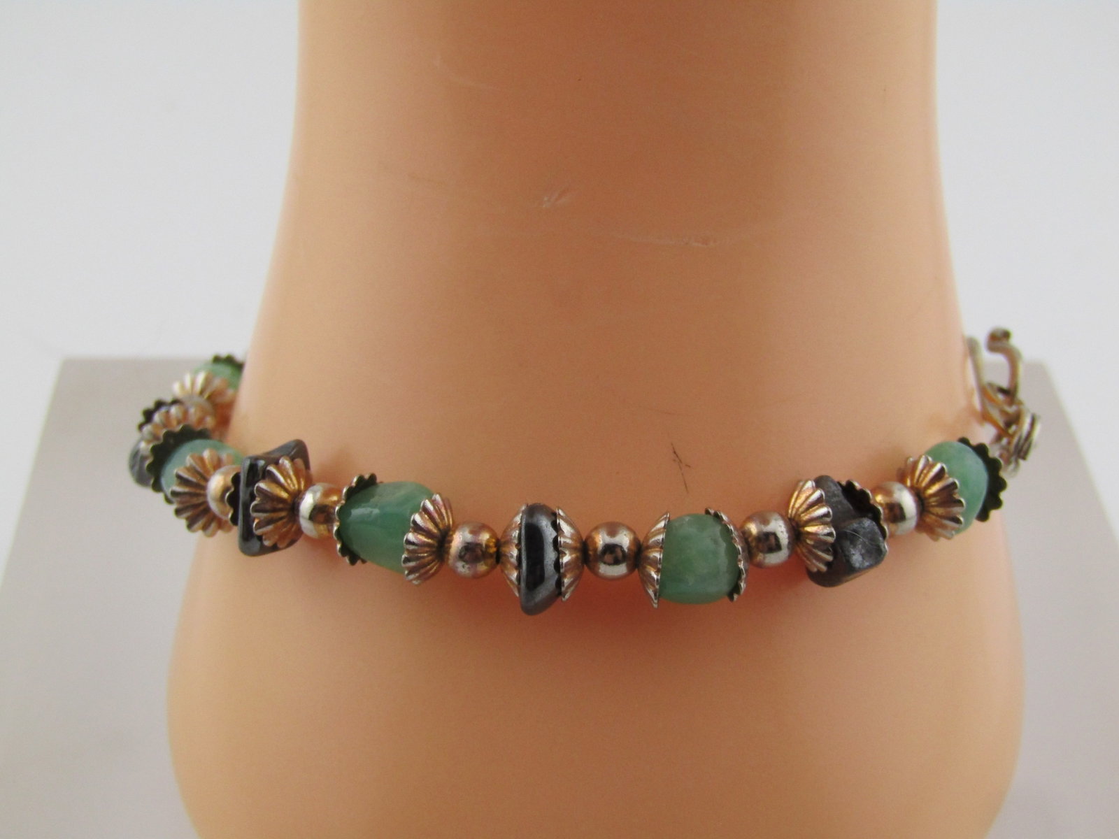 Vintage Green Agate & Hematite Beaded Bracelet, 8", Hook Clasp.: Vintage Green Agate & Hematite Beaded Bracelet, 8", Hook Clasp. Each bead has a fluted cap with a 3.5mm round silver tone bead between each of the agate and hematite beads. The metal seems to be a mix