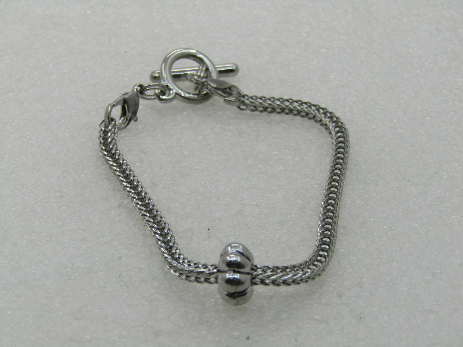 Vintage Wheat Link Toggle Bracelet, 7.5" Silver Tone: Vintage Wheat Link Toggle Bracelet, 7.5" Silver Tone. Age is appx. 1990's. It has a squared wheat link chain that is appx. 2.7mm wide with a fluted slide bead. Toggle clasp. Each clasp end is