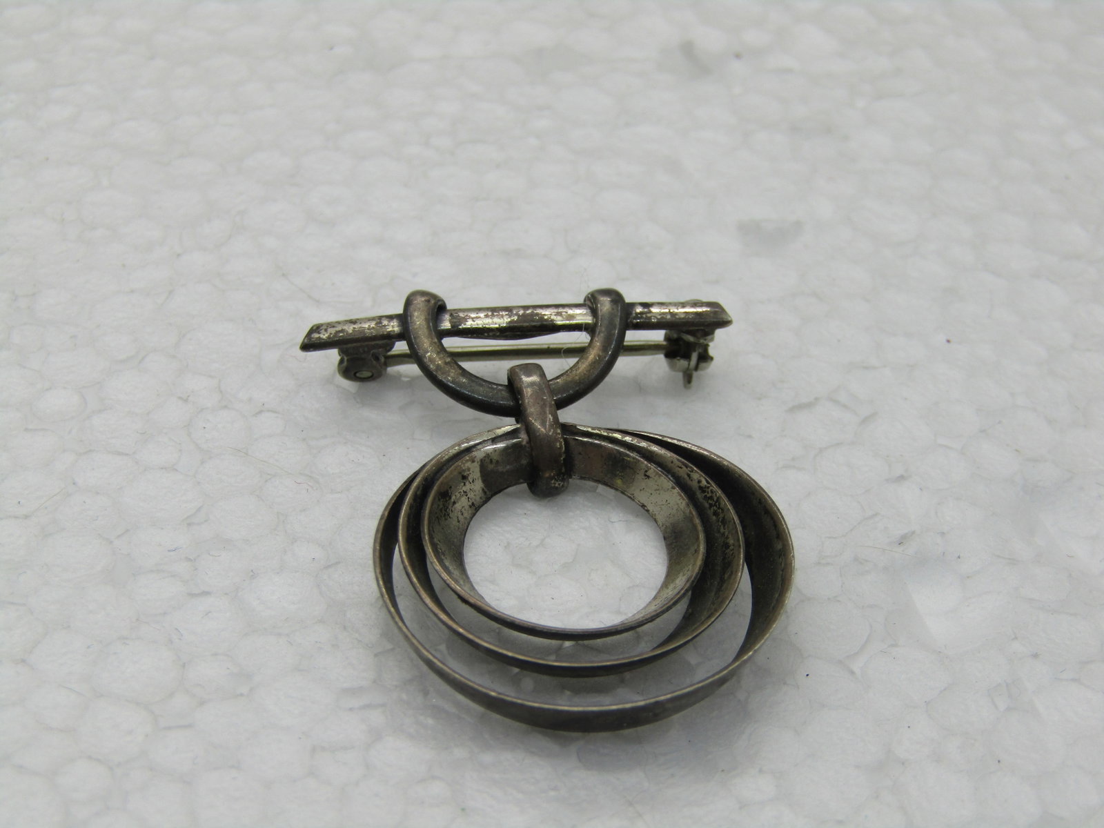 Vintage Sterling Bar & Circle Brooch, 1920's-1940's, 4.64 gr.: Vintage Sterling Bar & Circle Brooch, 1920's-1940's, 4.64 gr. This has a bar with a loop from which a triple concentric circle drops, tapered. The brooch is 1.25" long nad 1" wide. It is marked
