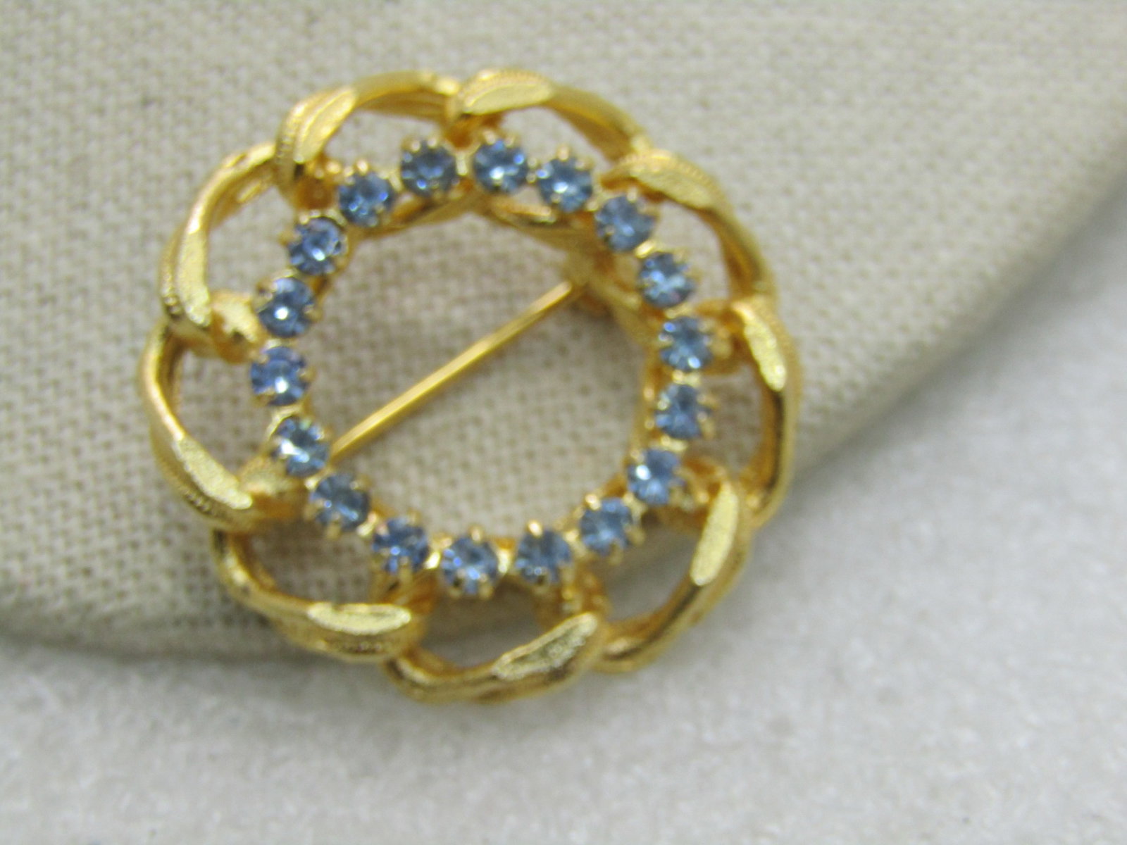 Vintage Blue Rhinestone Curb Link Circle Brooch, Gold Tone, 1.25", 1960's-1970's: Vintage Blue Rhinestone Curb Link Circle Brooch, Gold Tone, 1.25", 1960's-1970's. Textured gold tone curb link like circle brooch with a center halo of baby blue rhinestones. It is appx. 8mm wide and