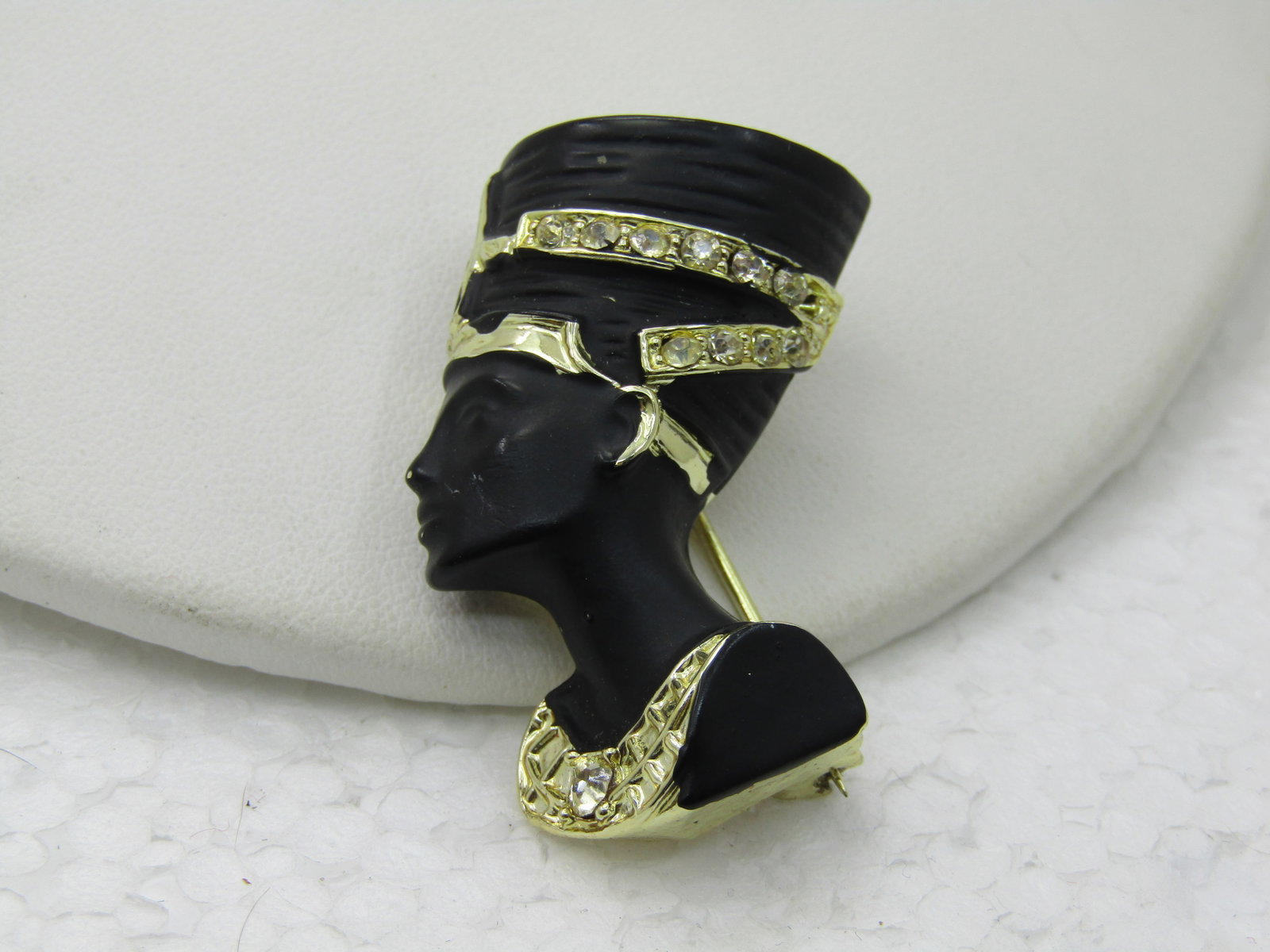 Vintage Egyptian Queen Nefrititi Brooch, Gold Tone and Black Enameling, 1-5/8": Vintage Egyptian Queen Nefrititi Brooch, Gold Tone and Black Enameling, 1-5/8" and 7/8" wide. 1980's, Gold tone bands on the headwar with rhinestones in the gold bands and in the necklace. 1980's,