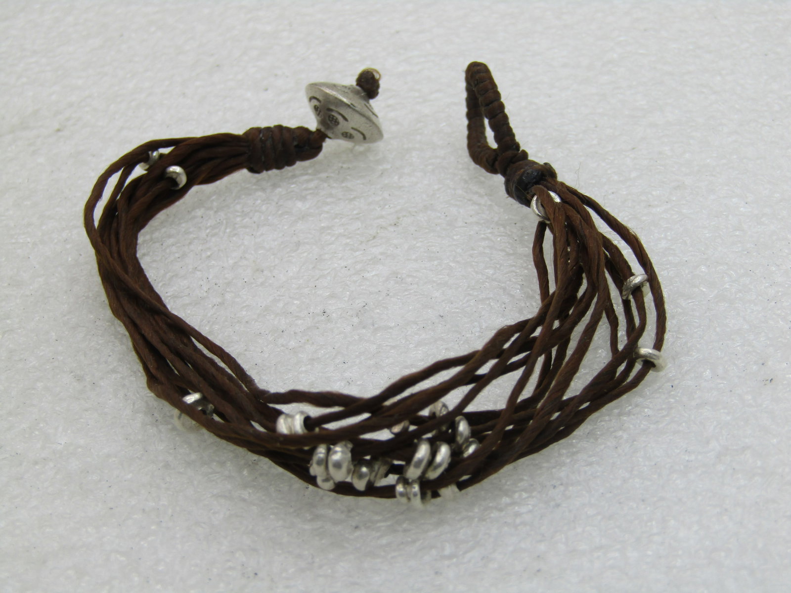 Vintage Brown Multi-Cord Beaded Bracelet, Tribal, Boho, 8", Loop Clasp: Vintage Brown Multi-Cord Beaded Bracelet, Tribal, Boho, 8", Loop Clasp. 11 brown cords with sliding silver tone disc beads. Stamped bead at the end where the loop slides over to close the bracelet -