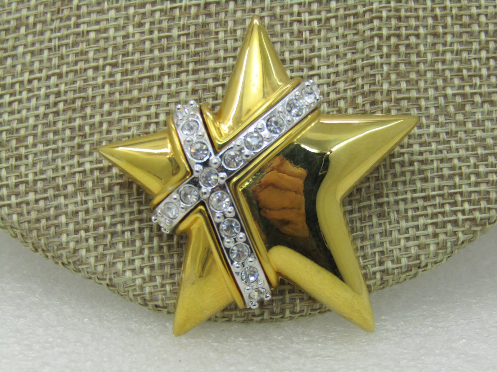 Vintage Joan Rivers Two Tone Star Brooch, CZ/Rhinestones 2": Vintage Joan Rivers Two Tone Star Brooch, CZ/Rhinestones 2" by 1.75', Offset Star with a silver tone band , raised, crossing over the star in an X pattern with clear rhinestones. Very good condition.