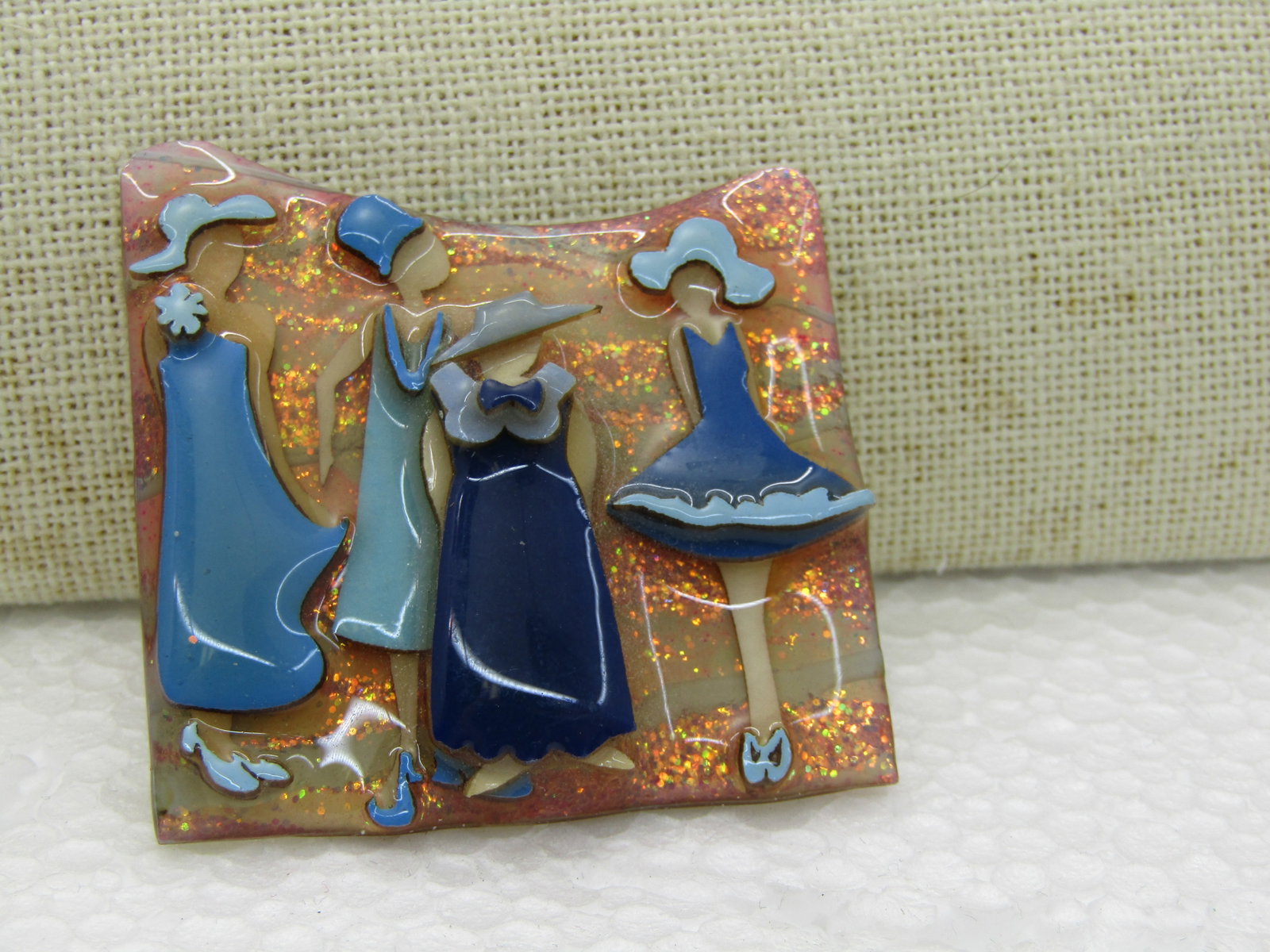 Lucinda's Woman Glittered Enameled Fashion Pin, 2": Lucinda's Woman Glittered Enameled Fashion Pin, 2" still made today - fashion scene with four women raised off the glittered background - looks, in a way like a storefront window. Very good