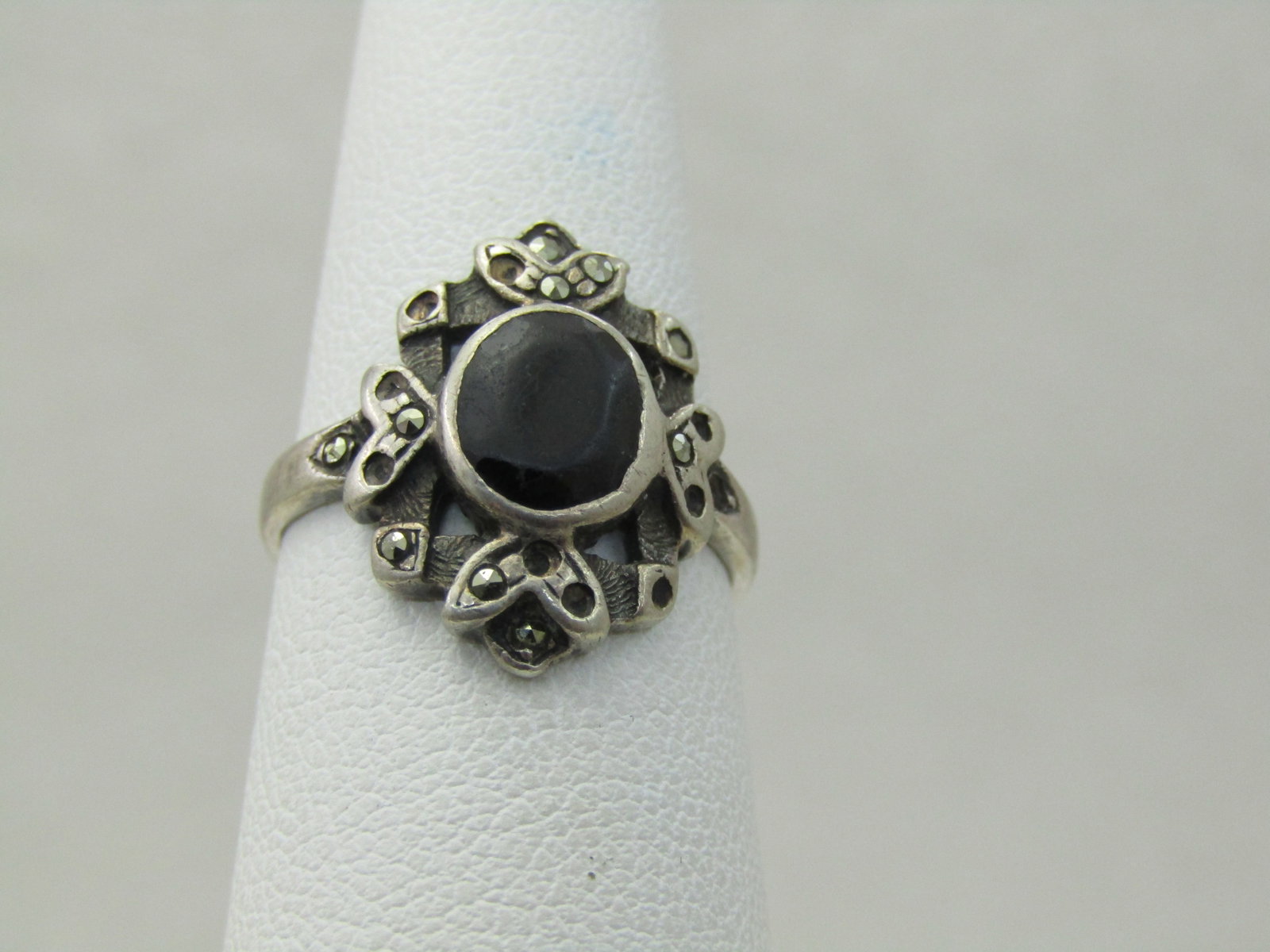 Vintage Sterling Silver Onyx Marcasite Ring, Sz. 6.5: Vintage Sterling Silver Onyx Marcasite Ring, Sz. 6.5. Weight ii appx 2.98 grams. 1960's-1970's, heart like designs on top, bottom and sides of the 7.5 oval onyx which is bezel set. There are some marc