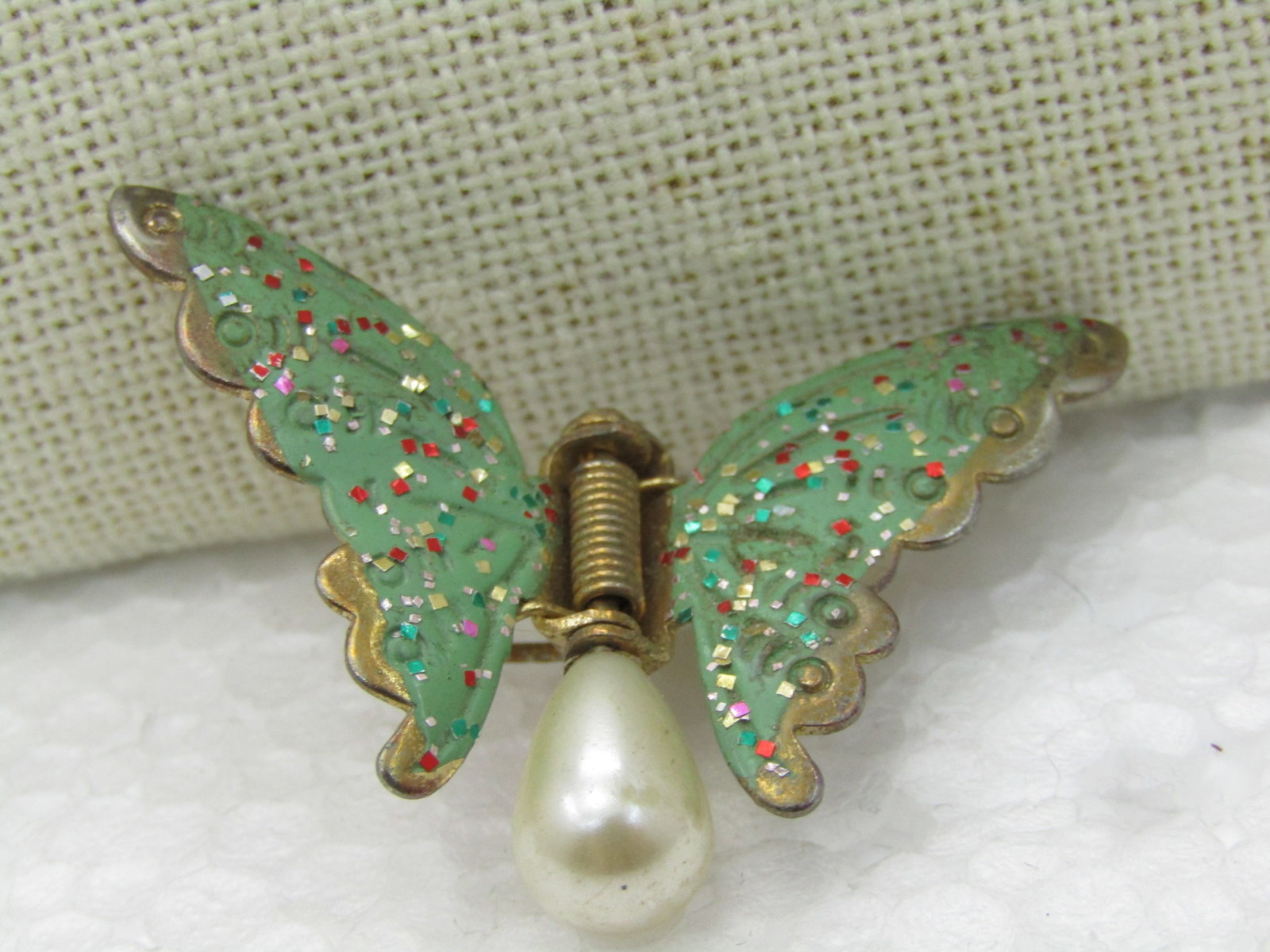 Vintage Green Enameled Butterfly Fur/Dress Clip, Faux Pearl, Early 1900's: Vintage Green Enameled Butterfly Fur/Dress Clip, Faux Pearl, 1920's-1940's. 1.75" wide and 1-1/8" tall - green leaves with glitter, hinged with a teadrop faux pearl- it is a wing with torso - there is