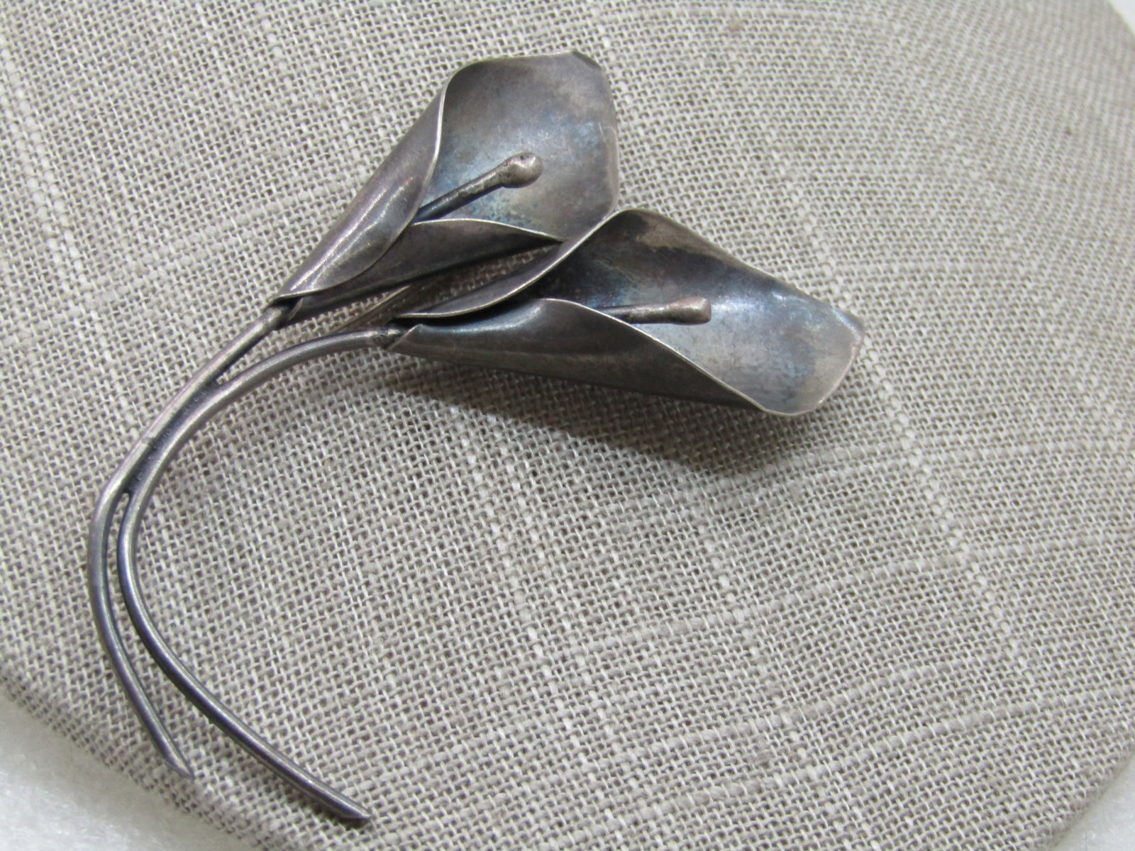 Vintage Stuart Nye Calla Lilies Brooch, 3", Double Stem: Vintage Stuart Nye Calla Lilies Brooch, 3", Double Stem. 2" wide at the widest point. 1960's-1970's. Signed with Stuart Nye's maker's mark, marked sterling and tested. Weight is appx. 11.95 gr. Bid