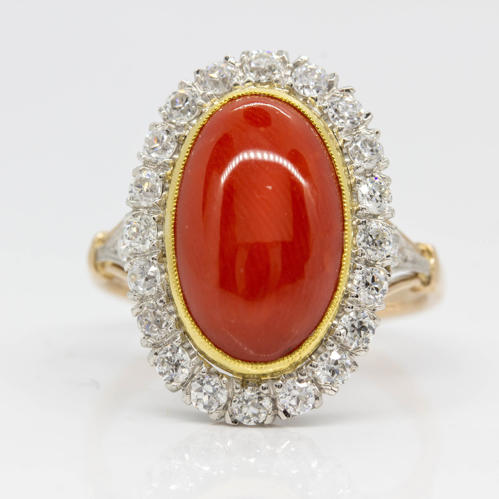 Estate 18k gold and Platinum Coral and Diamond Ring: Title: Estate 18k gold and Platinum Coral and Diamond Ring Description: This exquisite ring features an eye-catching natural coral that measures 13mm by 8mm. The center stone is surrounded by 24 old