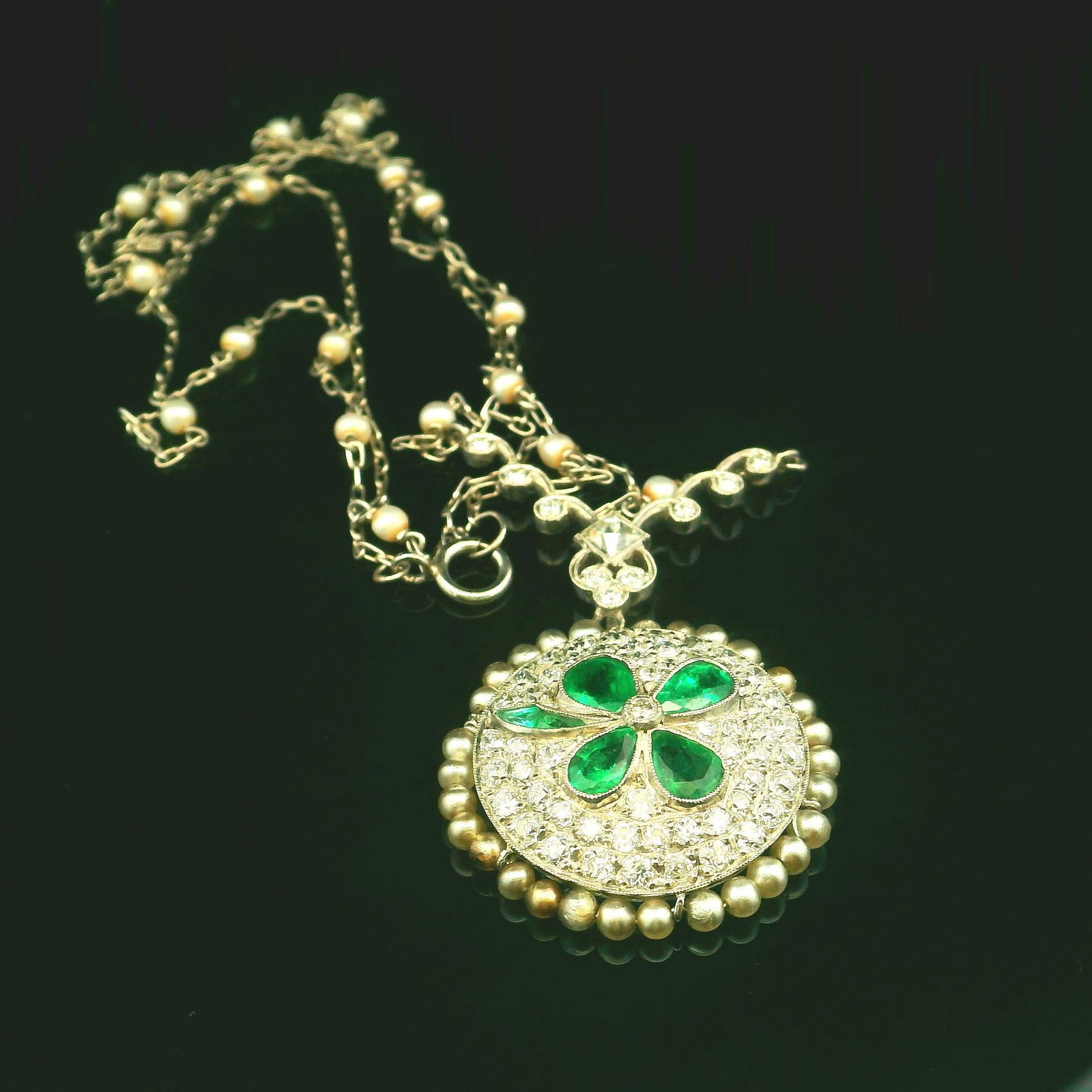 Platinum Natural Diamond and Emerald Pendant with Pearl Chain: Title: Platinum Natural Diamond and Emerald Pendant with Pearl Chain Description: This exquisite platinum pendant centers one natural French cut diamond of H Color and VS2 clarity that weighs 0.20ctw.