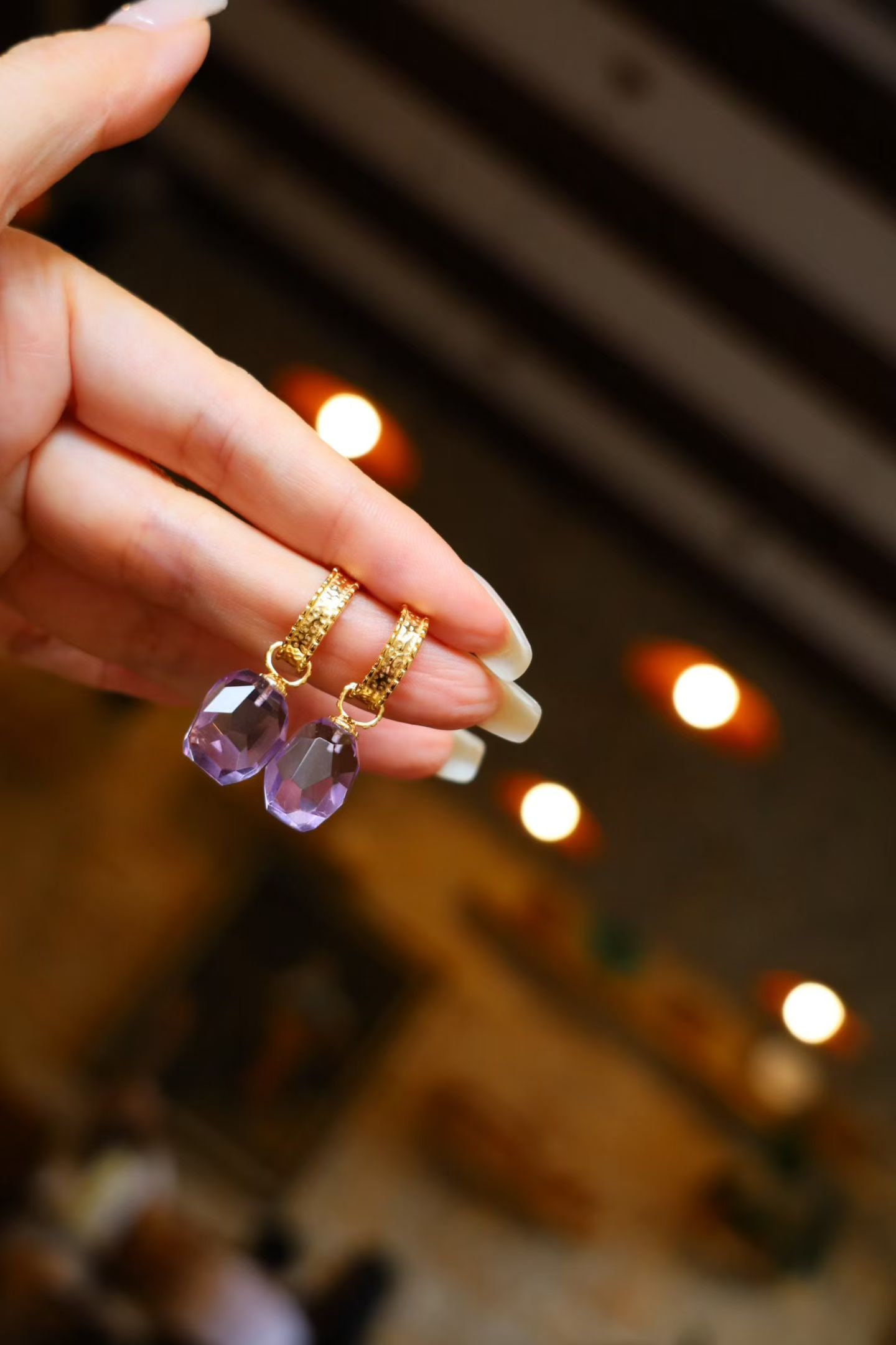 Natural Amethyst Earrings: Title: Natural Amethyst Earrings Description: Breaking the symmetrical constraints of traditional faceted gemstones, these earrings feature irregular freeform cuts. They are artfully arranged, casual