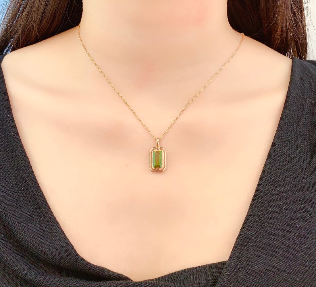 18K Gold Natural Tourmaline Pendant: Title: 18K Gold Natural Tourmaline Pendant Description: This pendant is meticulously crafted in 18K gold, featuring a natural tourmaline that exudes captivating color and brilliance. The surrounding