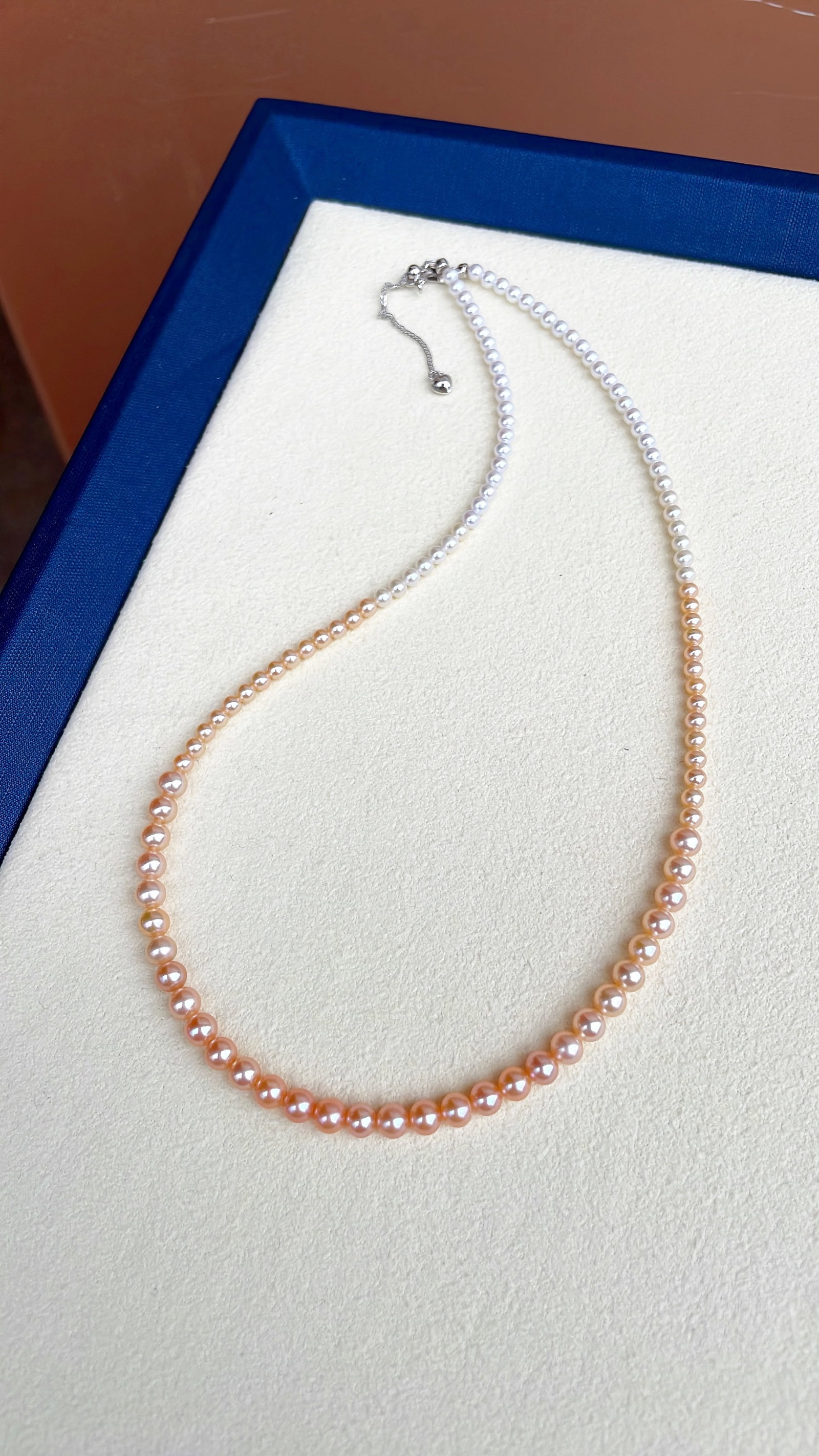 Natural Freshwater Pearl Necklace: Title: Natural Freshwater Pearl Necklace Description: This natural freshwater pearl necklace features a gentle Chinese red gradient color. The pearls are mostly round with a strong luster and slight