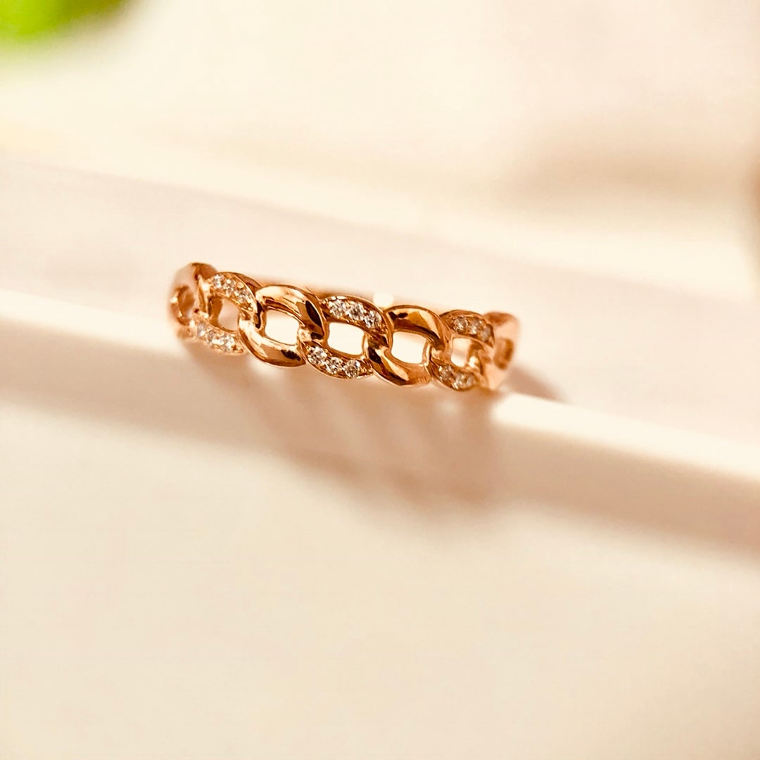 18K Gold Diamond Ring: Title: 18K Gold Diamond Ring Description: This 18K gold diamond ring features a unique chain design that exudes a sense of fashion. The exquisite setting allows the diamond to shine brilliantly under 