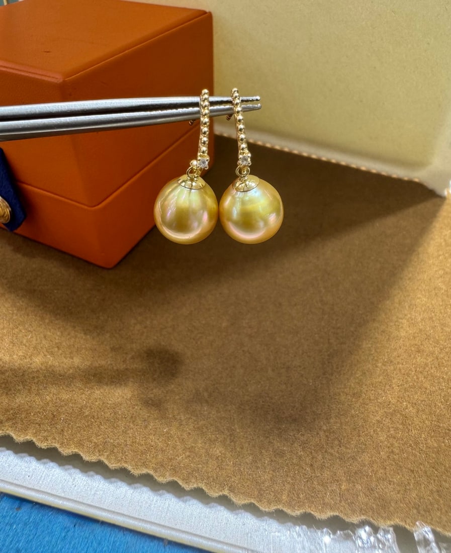 18K Gold Diamond Bead Earrings: Title: 18K Gold Diamond Bead Earrings Description: These earrings feature 18K gold with diamonds, paired with Philippine golden pearls. The pearls measure between 10 to 11mm, exhibiting a near-round