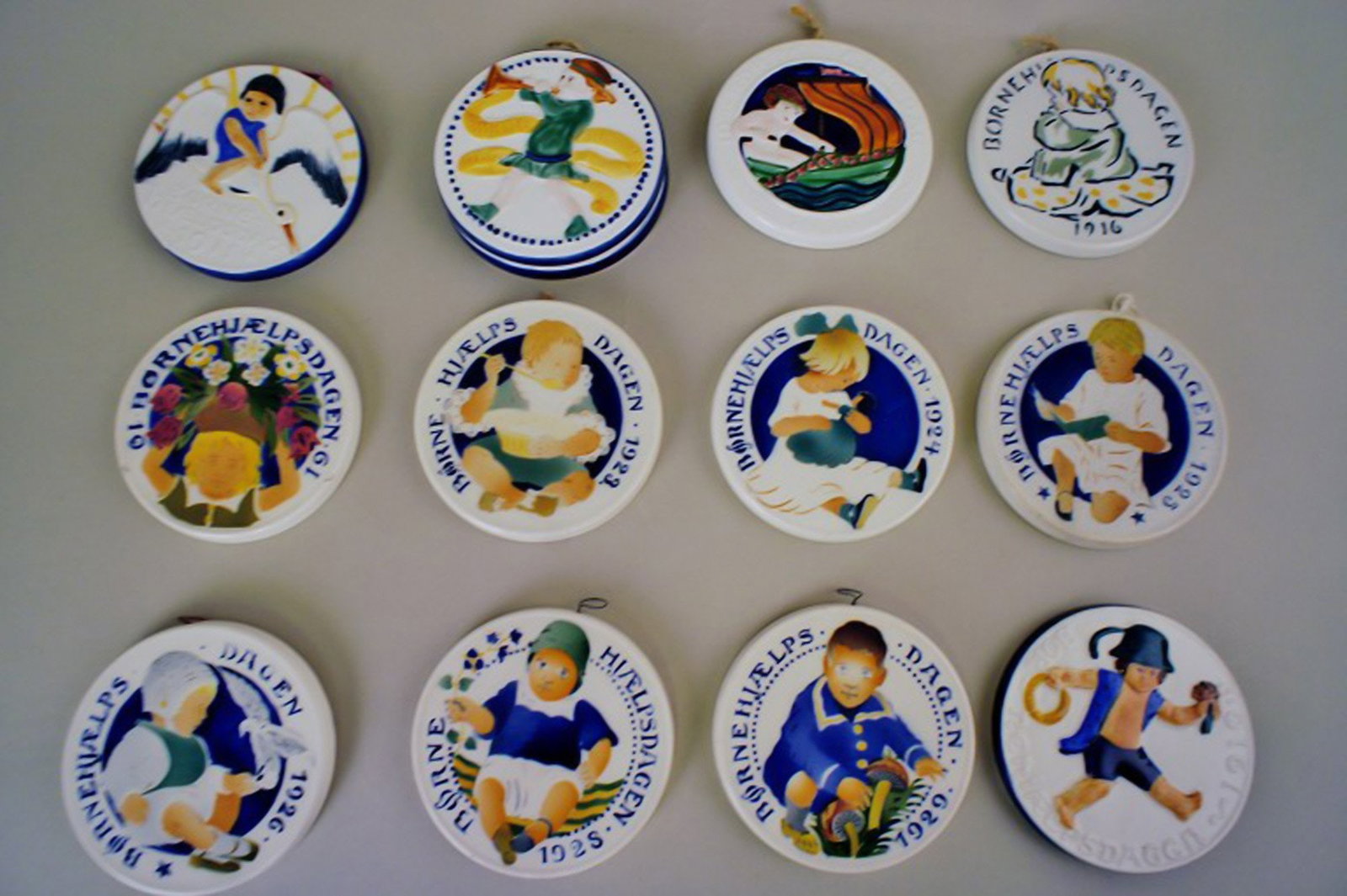 Aluminia child day year-plates.: Title: Aluminia child day year-plates. Description: Aluminia child day year-plates in faience. In good condition, Measures 8.5 cm. Years: 1912,16 and 24-28 (minus 1926, 1927) Brand: Aluminia Reserve: