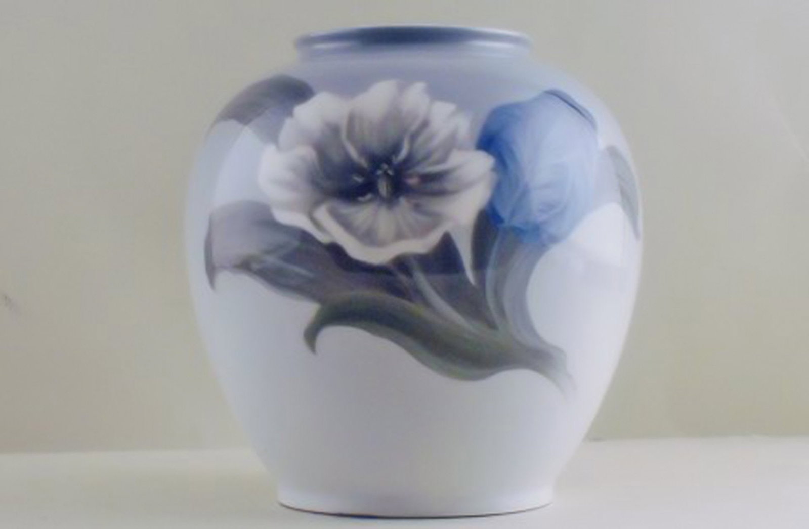 Royal Copenhagen vase with a flower and butterflies.: Title: Royal Copenhagen vase with a flower and butterflies. Description: Royal Copenhagen vase with a flower and butterflies. Measures 20 x 22 cm. Factory second, in good condition. Brand: Royal Copen