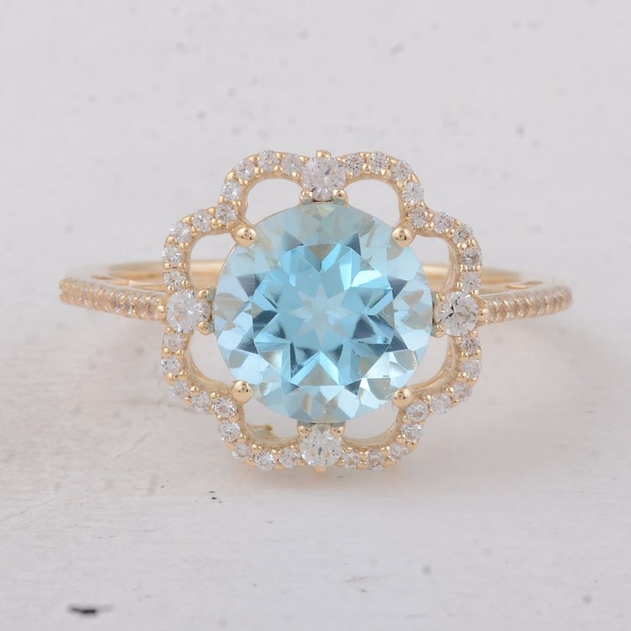 3.69 Ct Round Blue Topaz 9K Gold Ring: 3.69 Total Carat Blue Topaz 9K Gold Ring Specifications: Total Weight 2.7 g Center Gemstone Blue Topaz Gemstone Carat Weight 3.27 Carats Gemstone Measurements 9 mm Additional Gemstones White Sapphire 