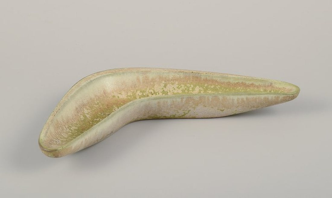 Gunnar Nylund for Rorstrand, Sweden. Boomerang-shaped ceramic bowl. Eggshell glaze in light green: Gunnar Nylund for Rorstrand. Boomerang-shaped ceramic bowl. Eggshell glaze in light green and sand-colored tones. Mid-20th century. Marked. In perfect condition. Second factory quality. Dimensions: W 